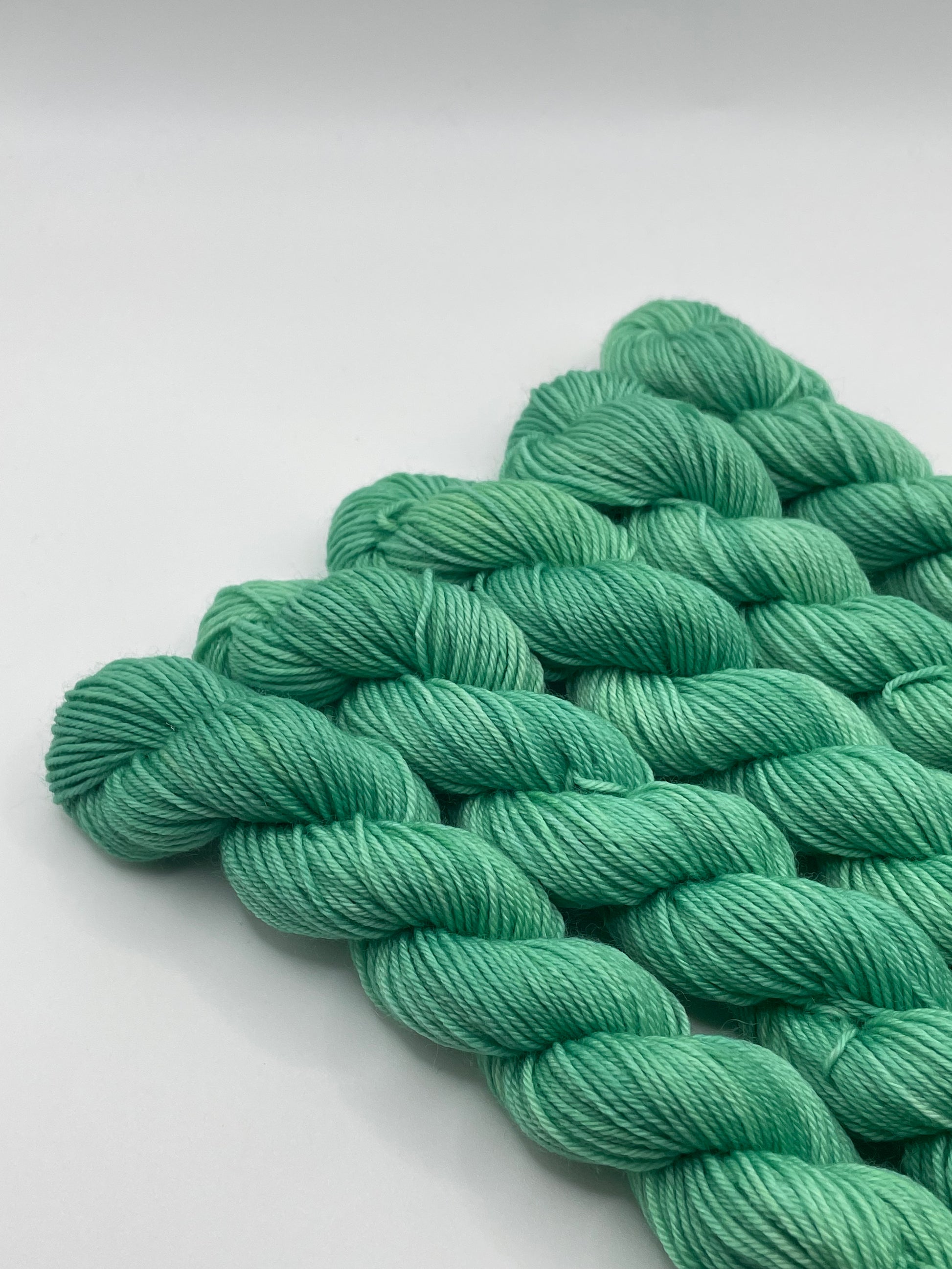 Green yarn mini skeins on a white background