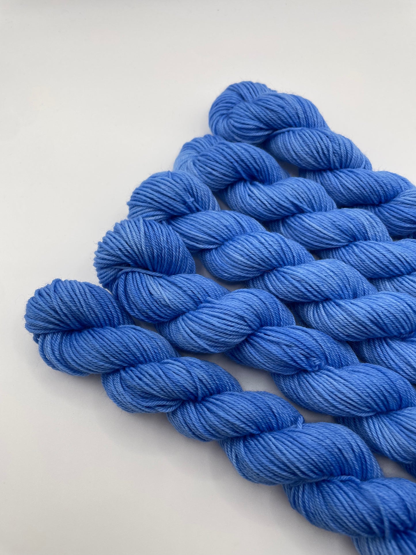 Blue yarn mini skeins on a white background