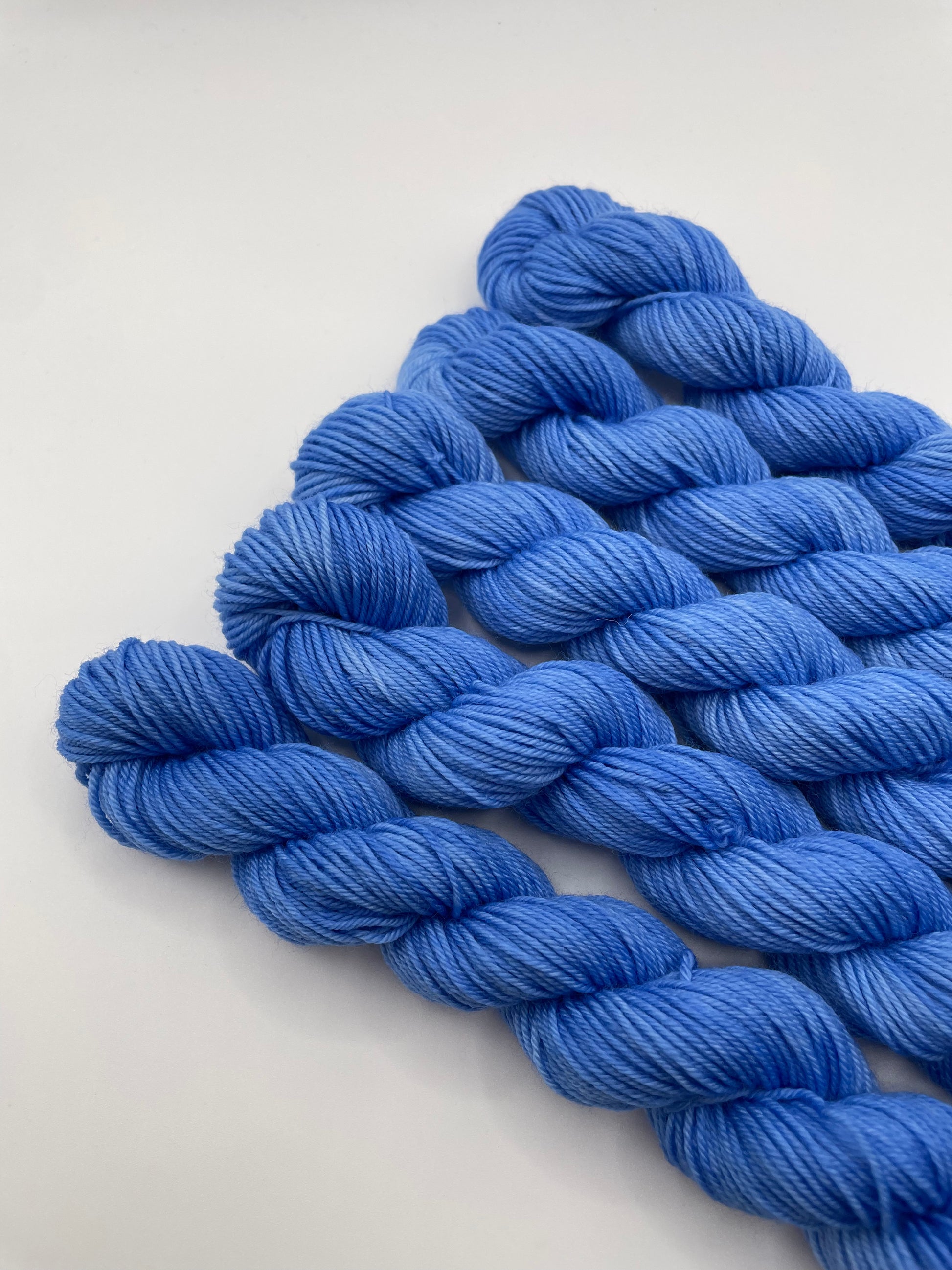 Blue yarn mini skeins on a white background