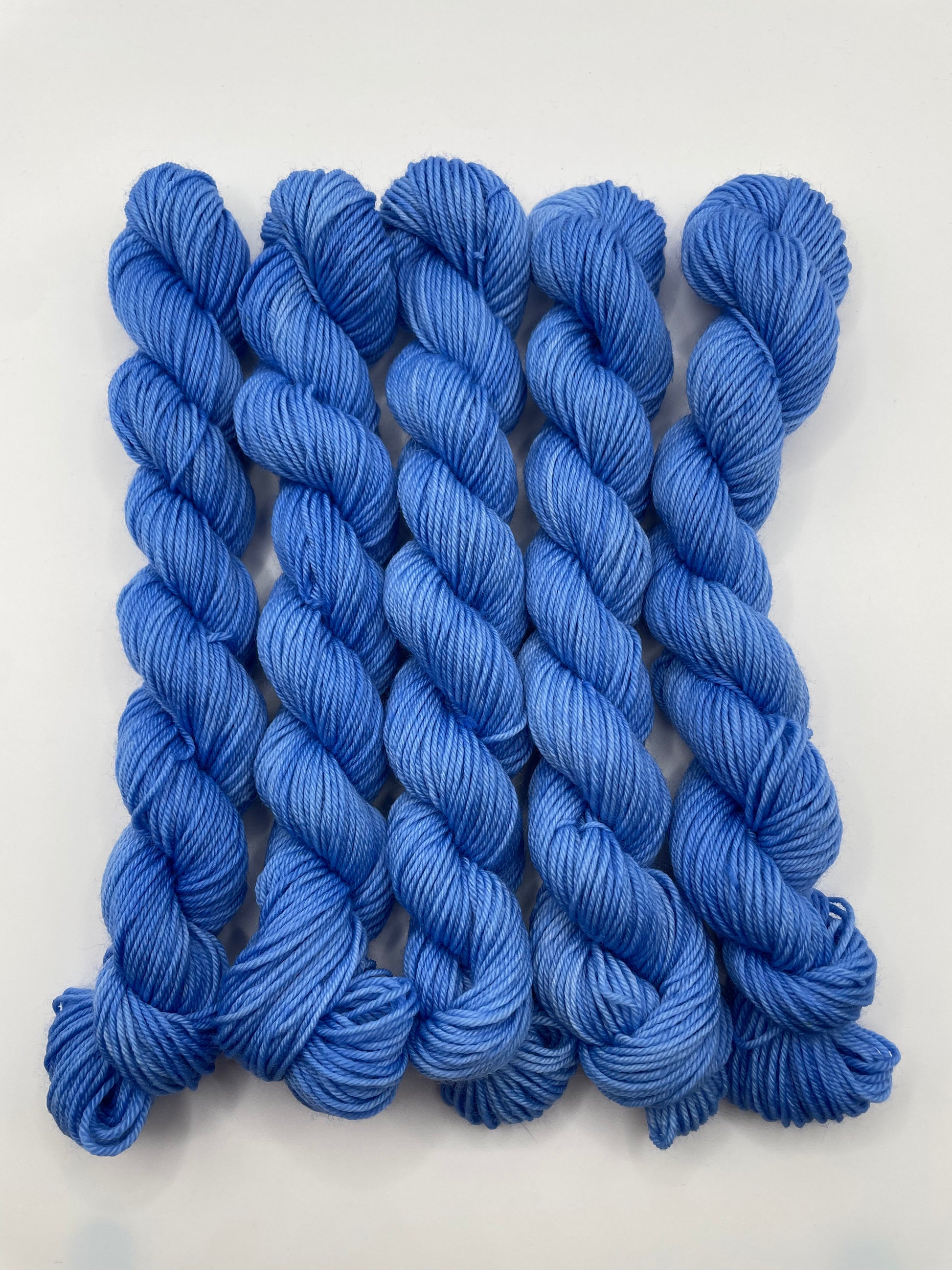 Blue yarn mini skeins on a white background