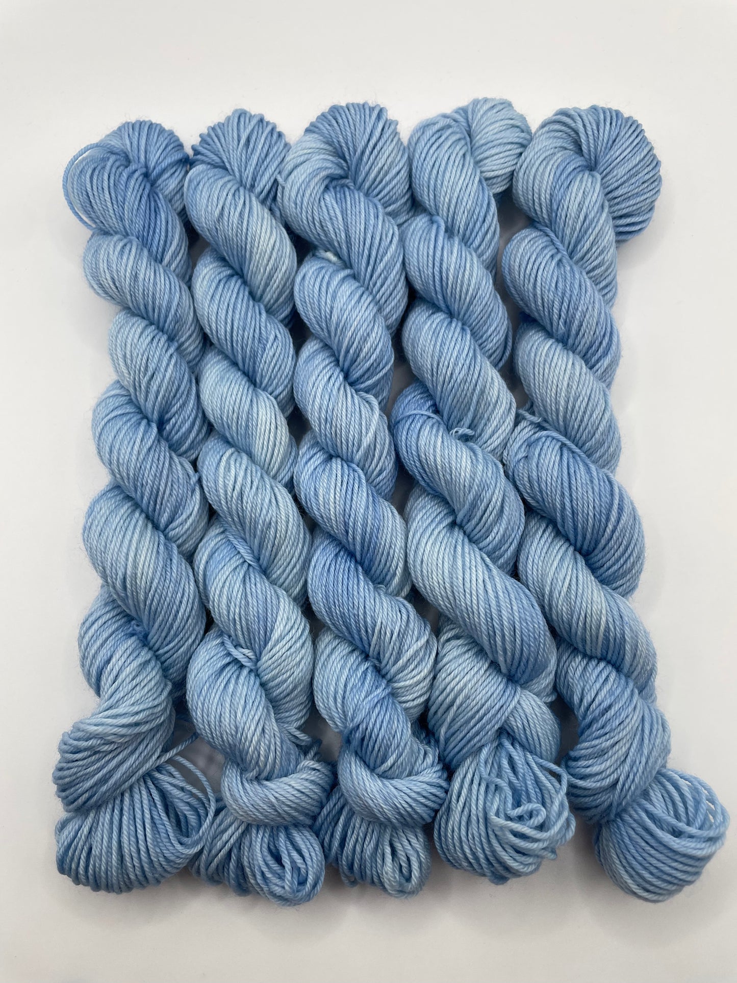 Blue yarn mini skeins on a white background