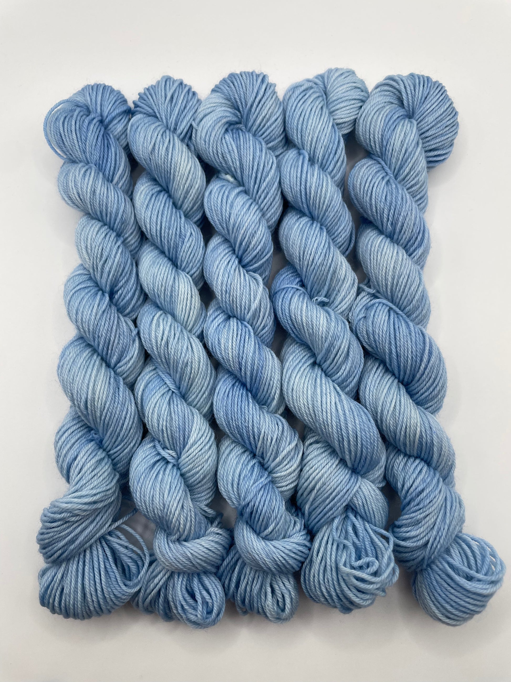 Blue yarn mini skeins on a white background