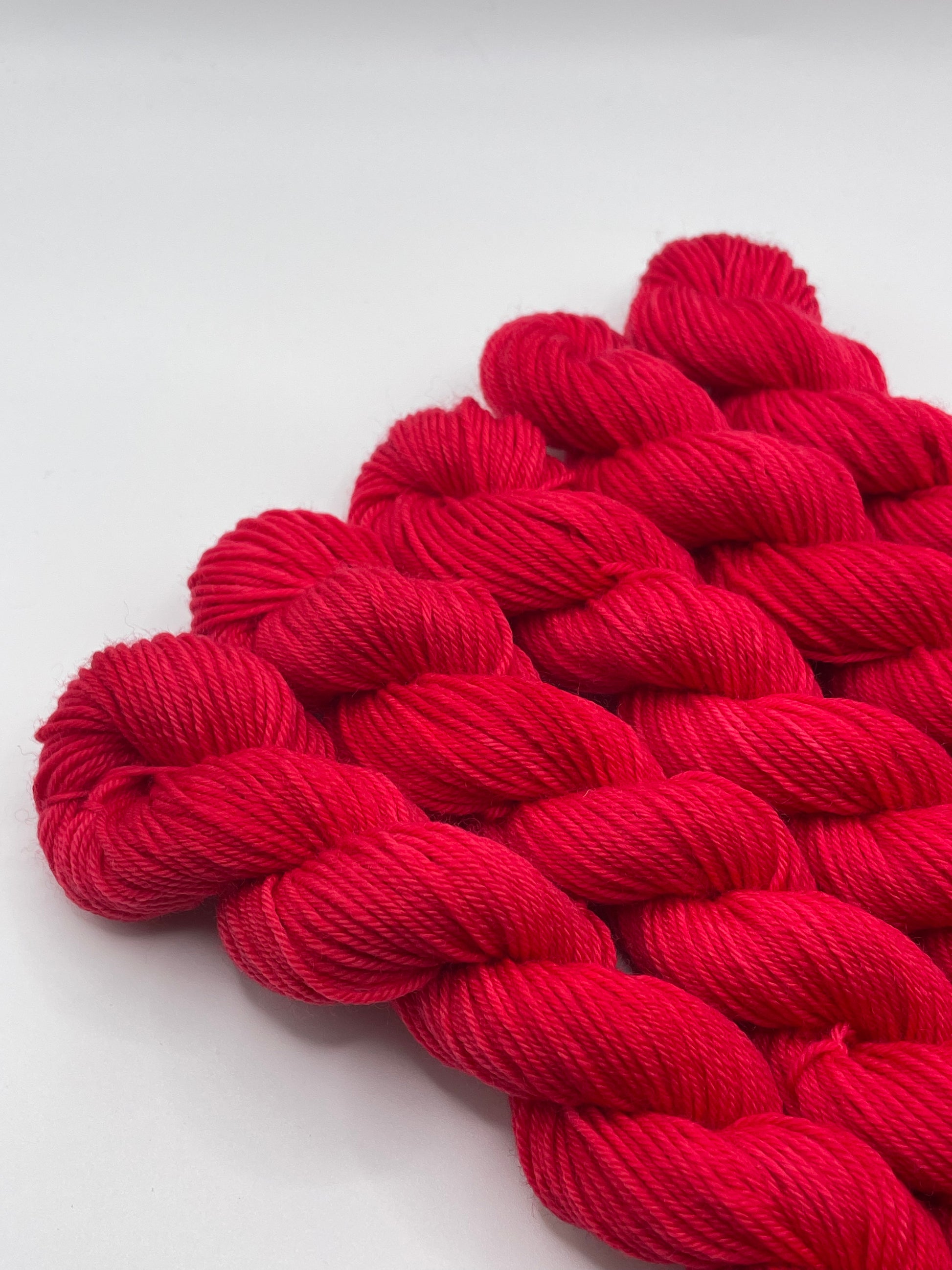 Red yarn mini skeins on a white background