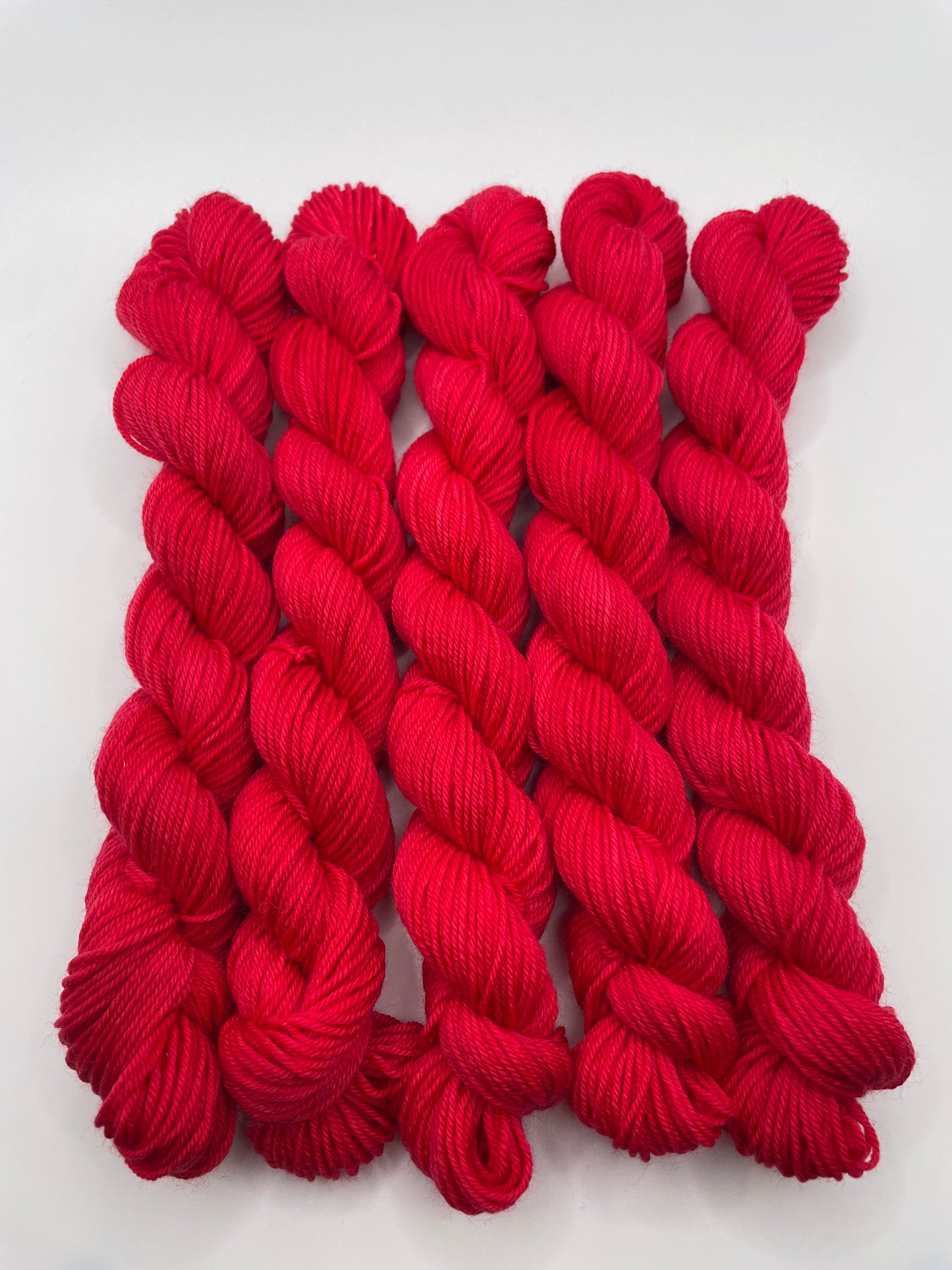 Red yarn mini skeins on a white background
