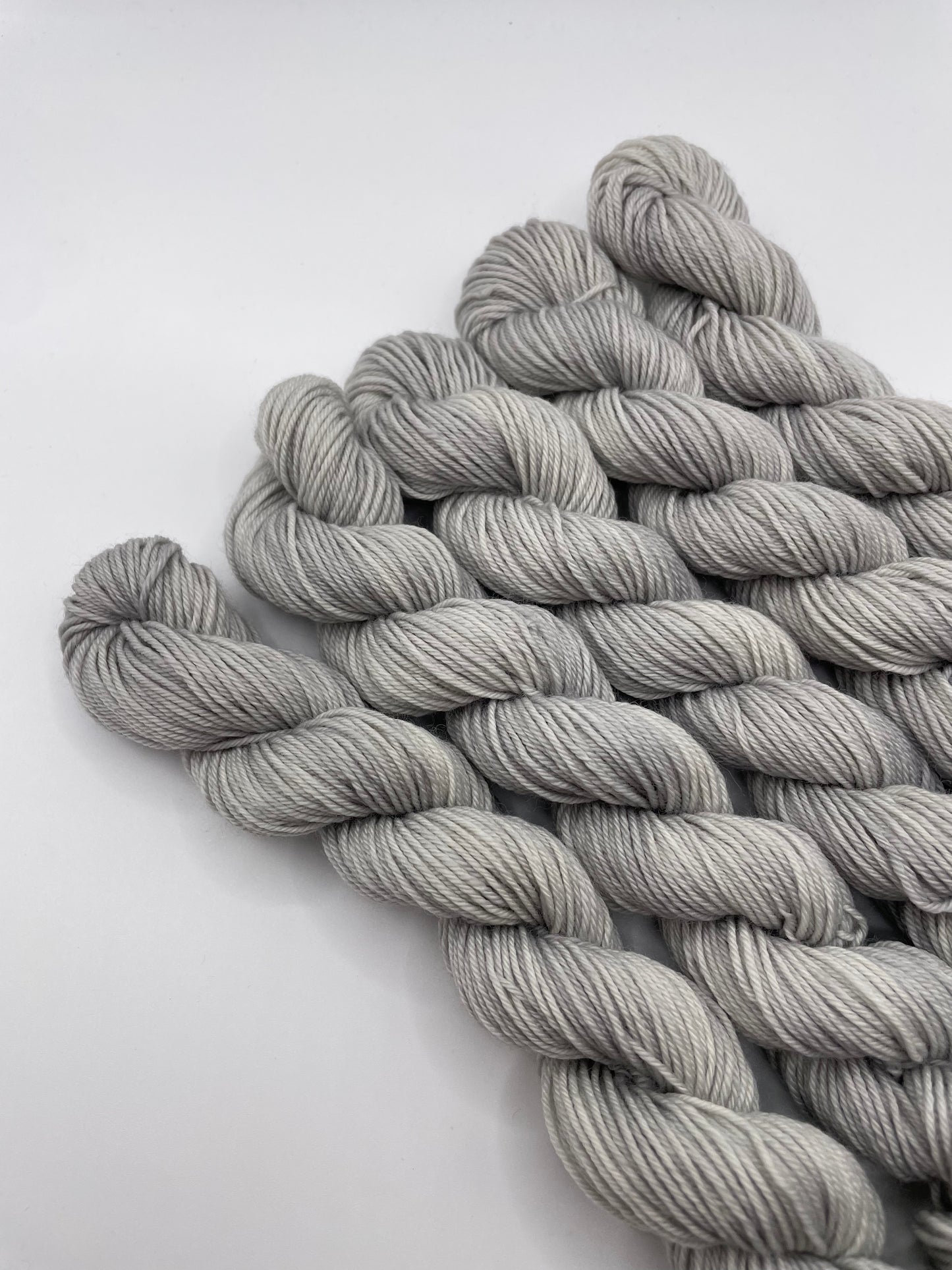 Grey yarn mini skeins on a white background