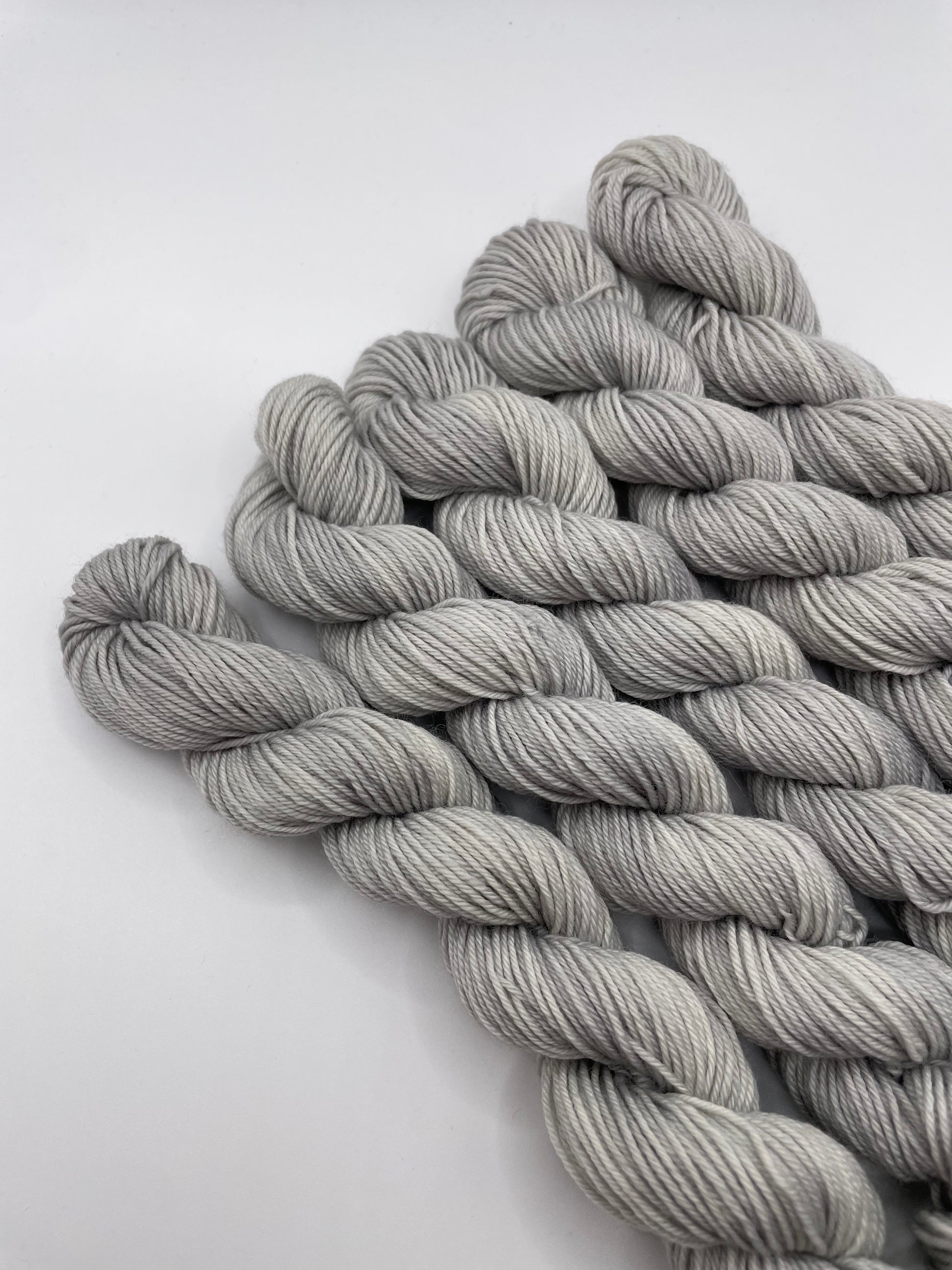 Grey yarn mini skeins on a white background