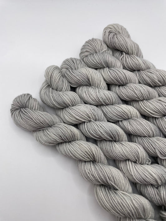 Grey yarn mini skeins on a white background