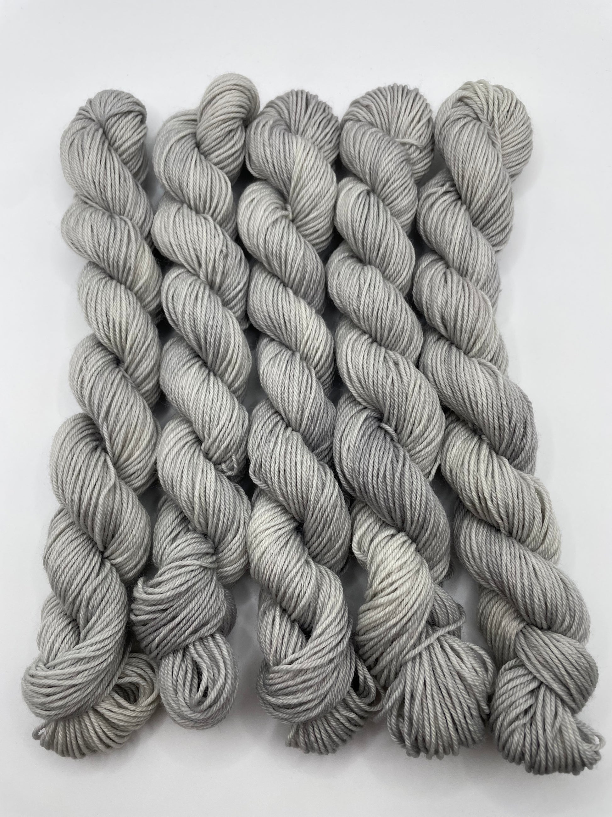 Grey yarn mini skeins on a white background