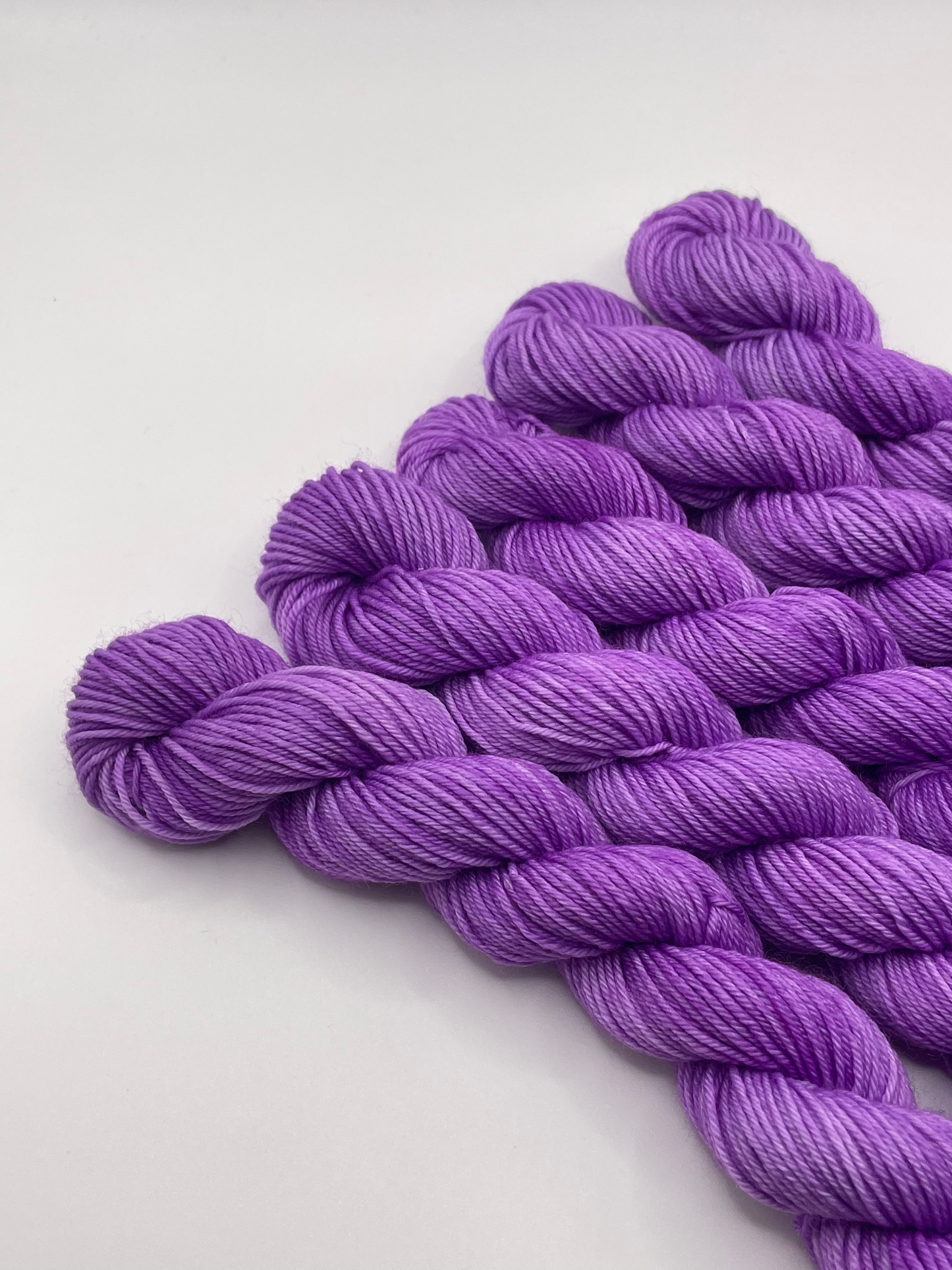 Purple yarn mini skeins on a white background