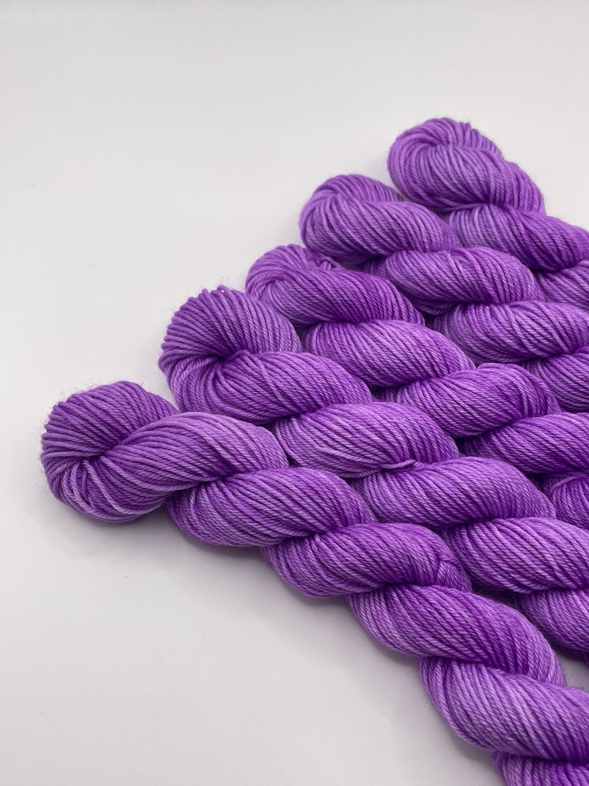 Purple yarn mini skeins on a white background