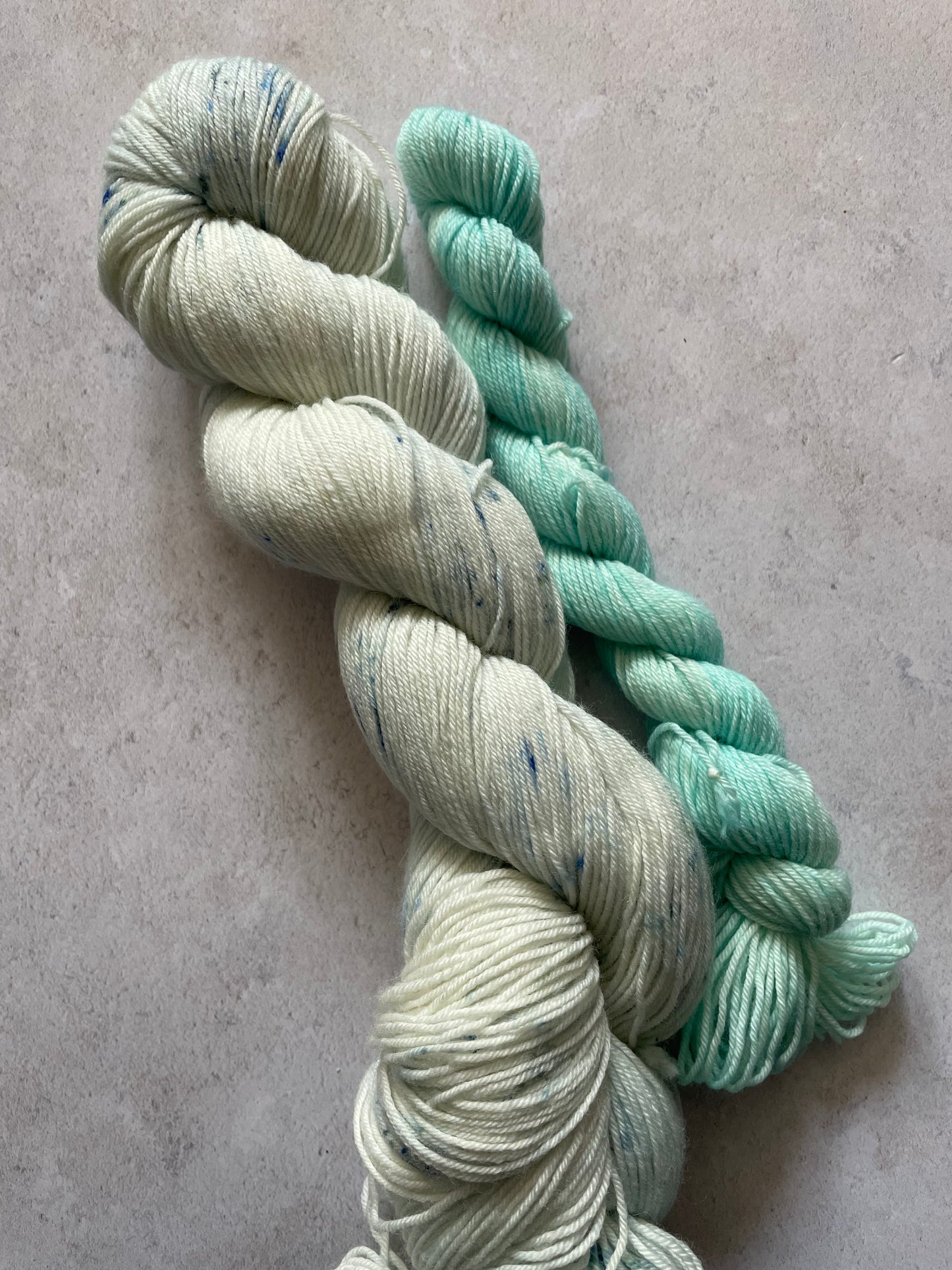 120g sock set with very lightly speckled main skein and aqua mini skein