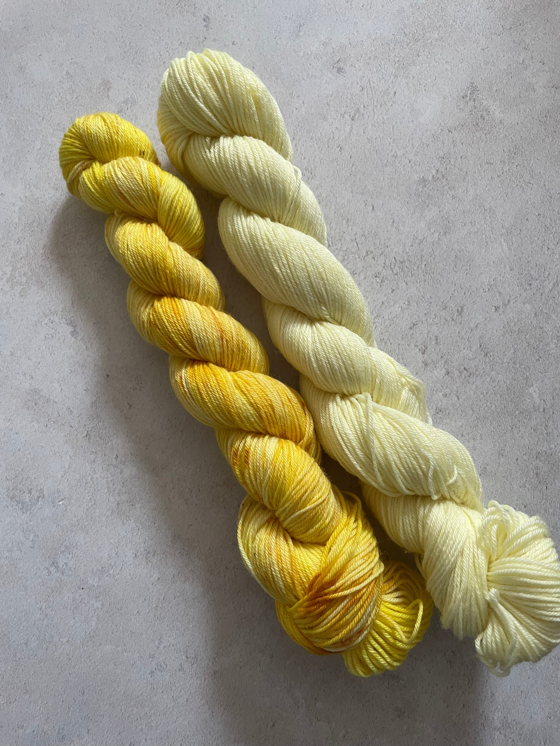 One 50g variegated yellow skein and one 50g pale yellow skein