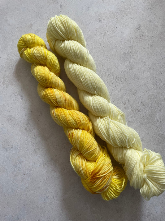 One 50g variegated yellow skein and one 50g pale yellow skein