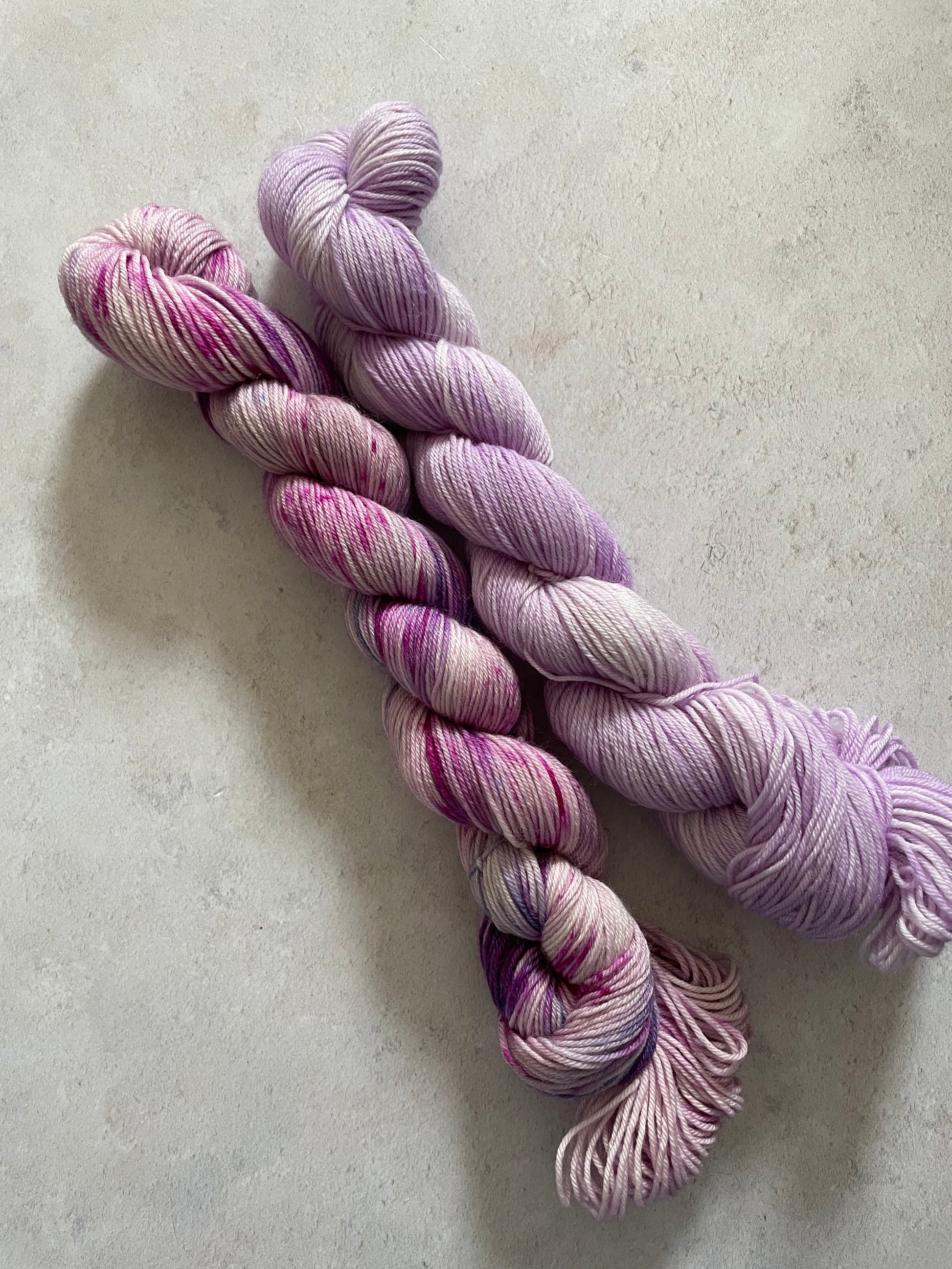 One 50g variegated purple skein and one 50g lilac skein