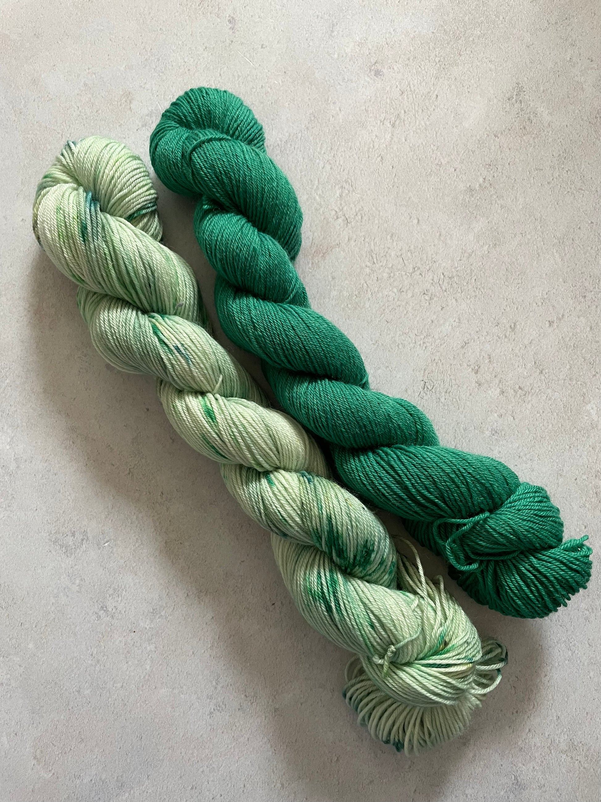 One 50g variegated pale green skein and one 50g emerald skein