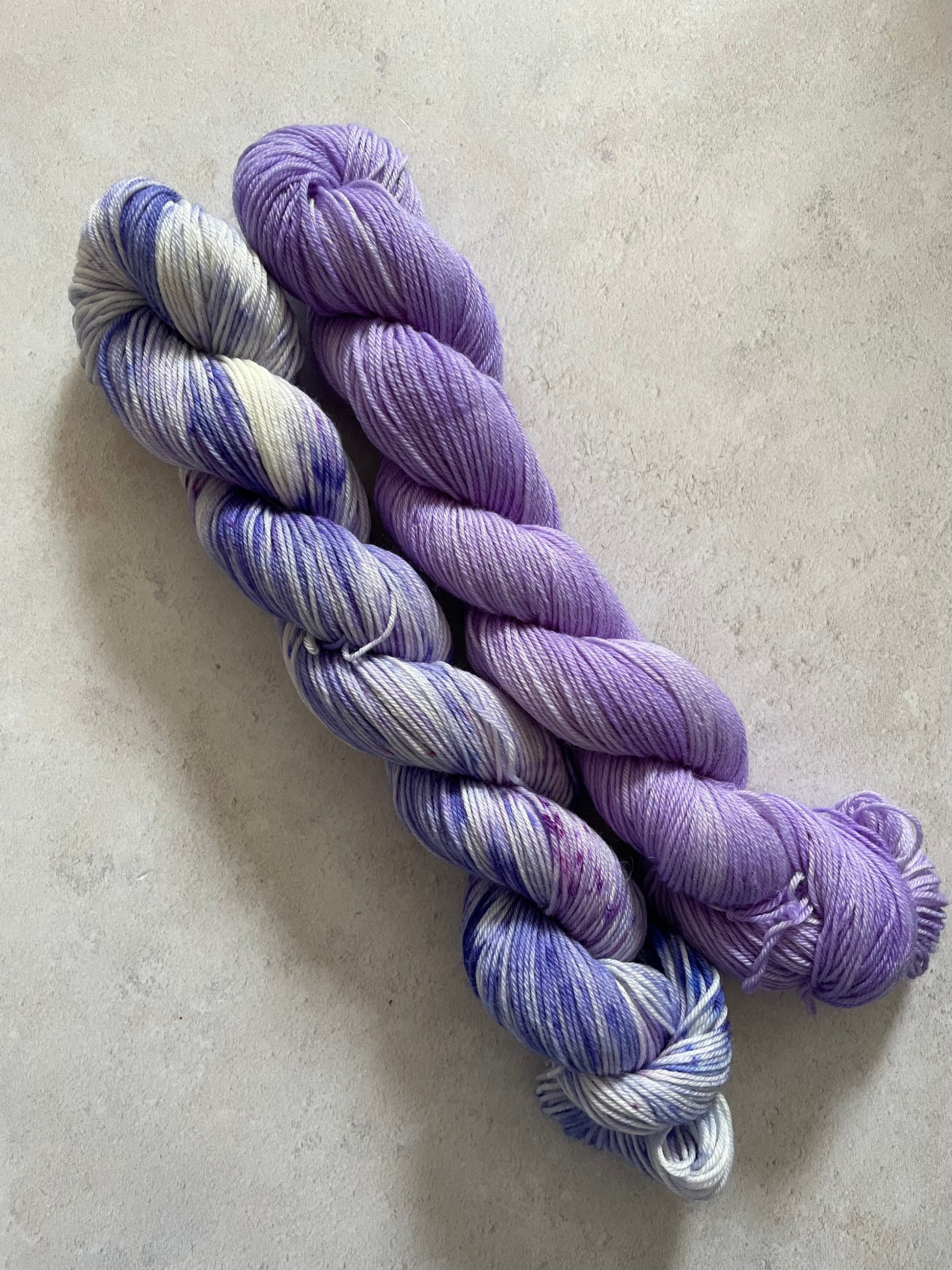 One 50g variegated purple skein and one 50g purple skein