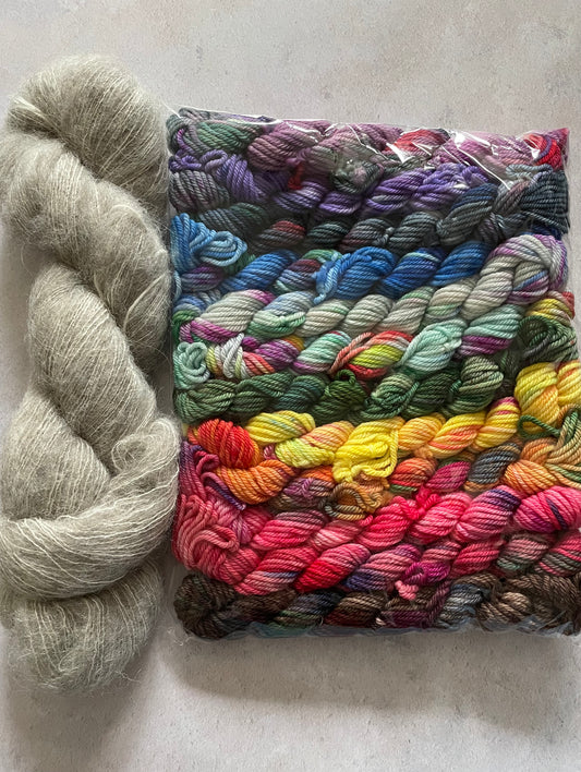 Skein of grey fluff yarn and 12 10g double knitting weight minis