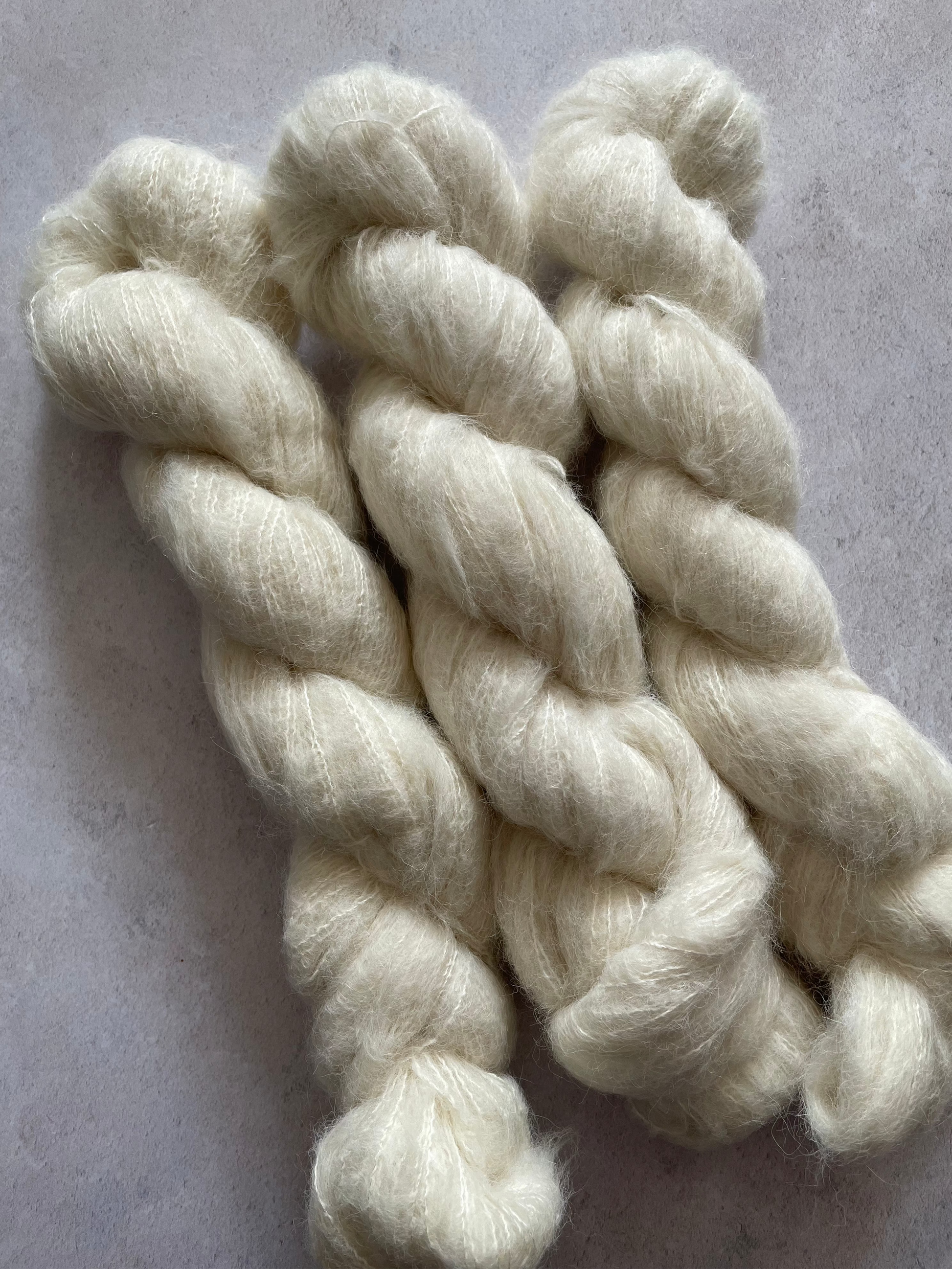 Three skeins of soft and fluffy cream yarn