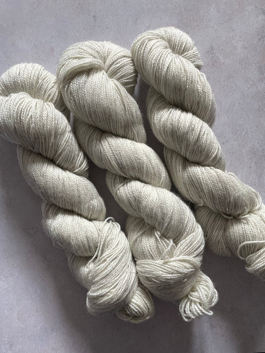 Three skeins of undyed bronze sparkle sock