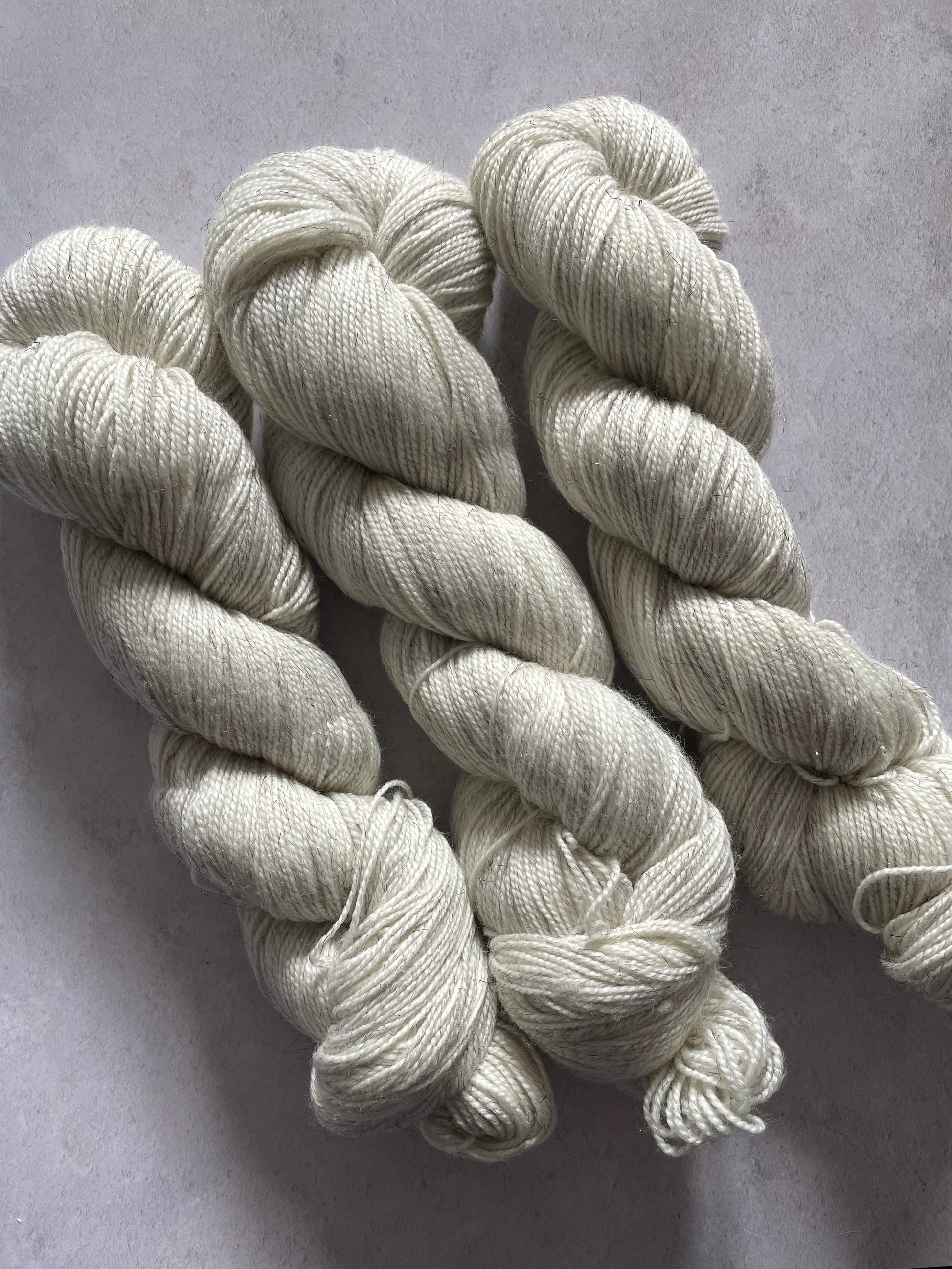 Three skeins of undyed bronze sparkle sock