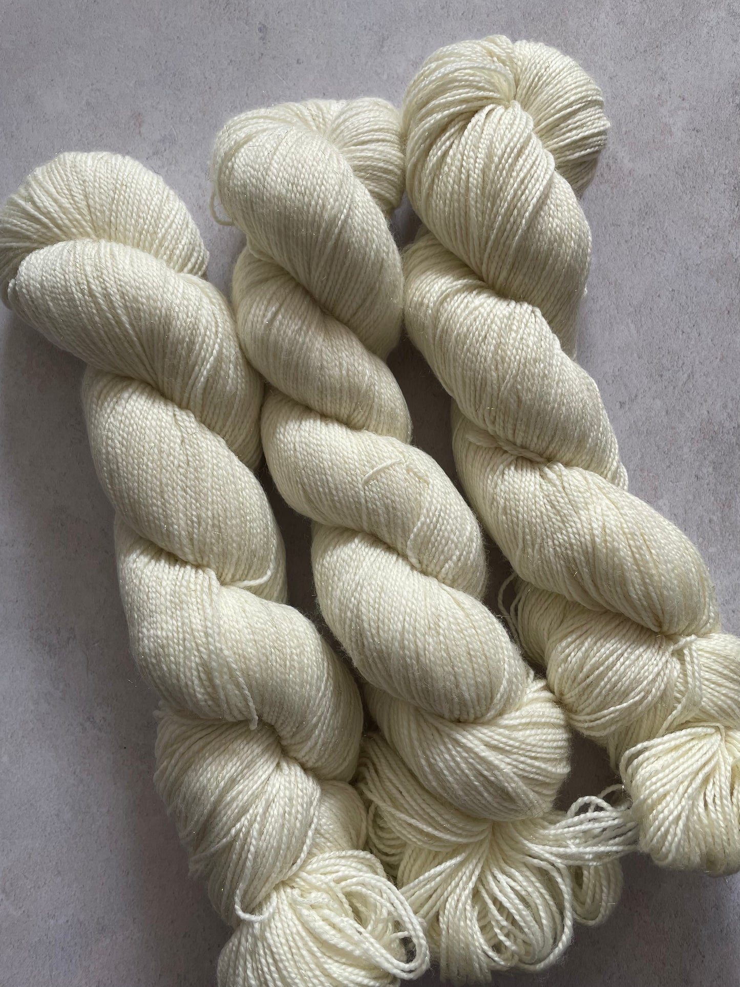 Three skeins of undyed gold sparkle sock