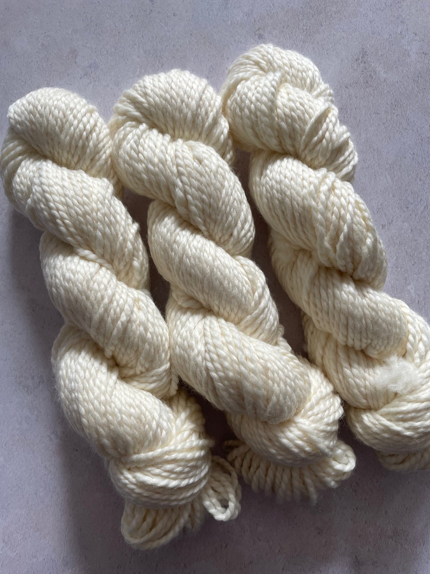 Three skeins of undyed chunky yarn
