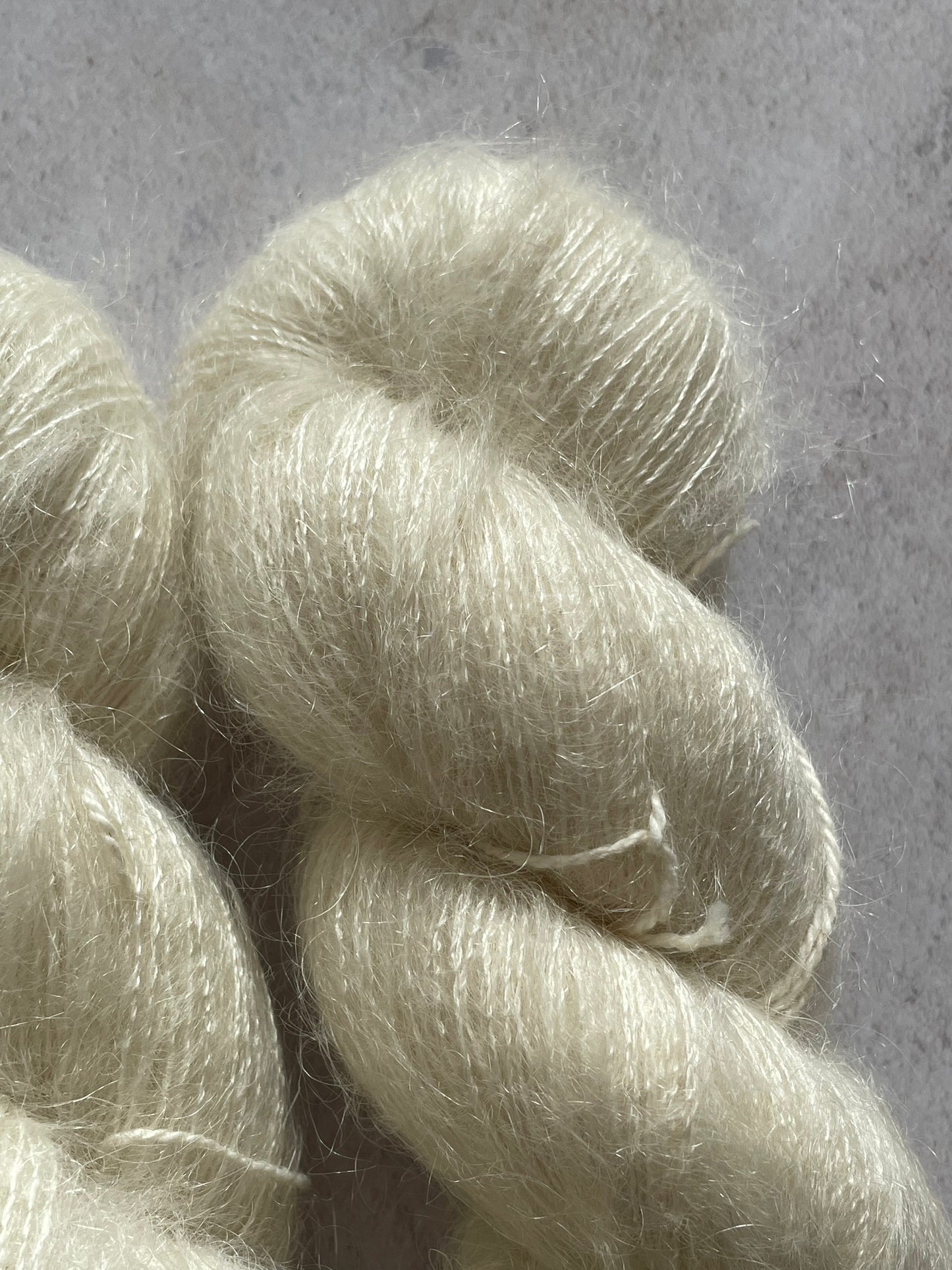 A close up of undyed kid mohair and silk yarn