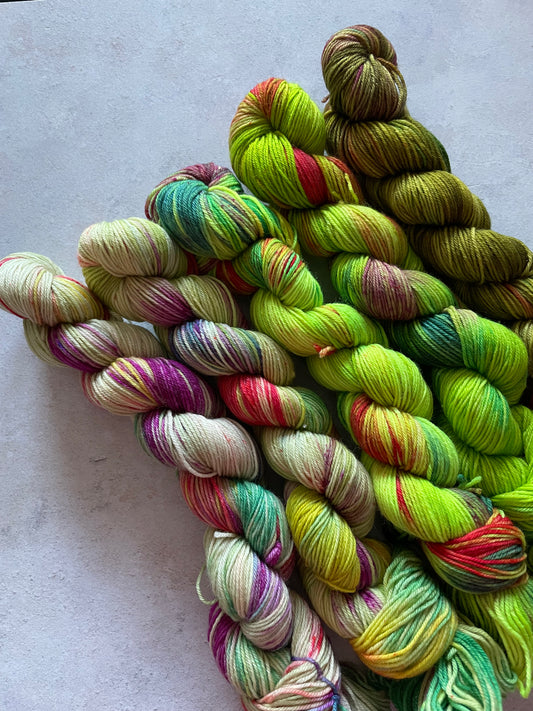 5 skeins of multicoloured and green yarn in different shades
