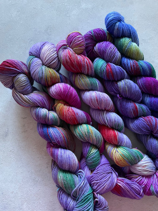5 skeins of multicoloured and violet yarn in different shades