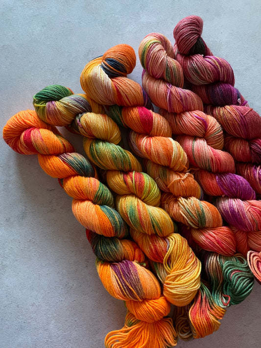 5 skeins of multicoloured and orange yarn in different shades