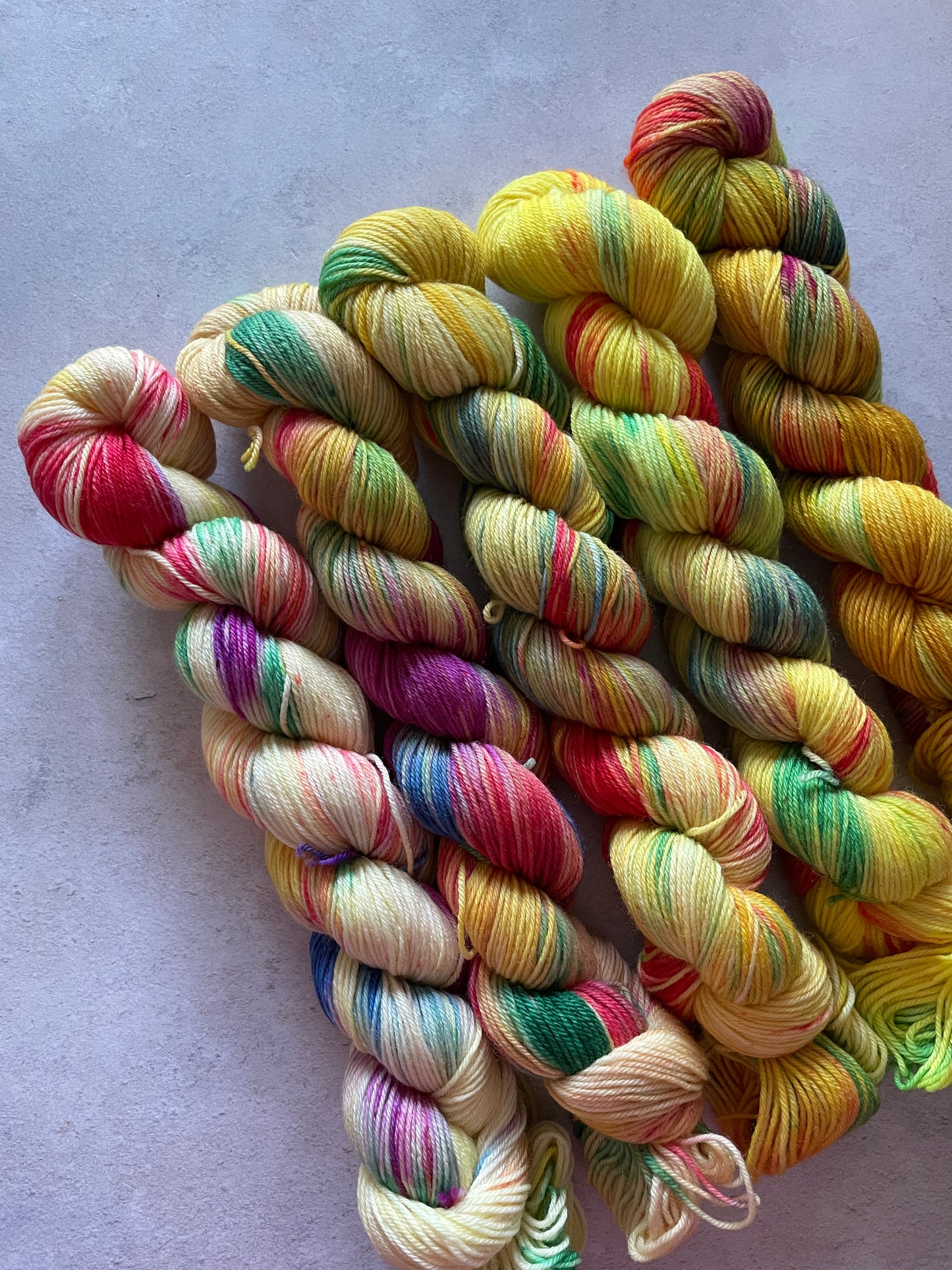 5 skeins of multicoloured and yellow yarn in different shades