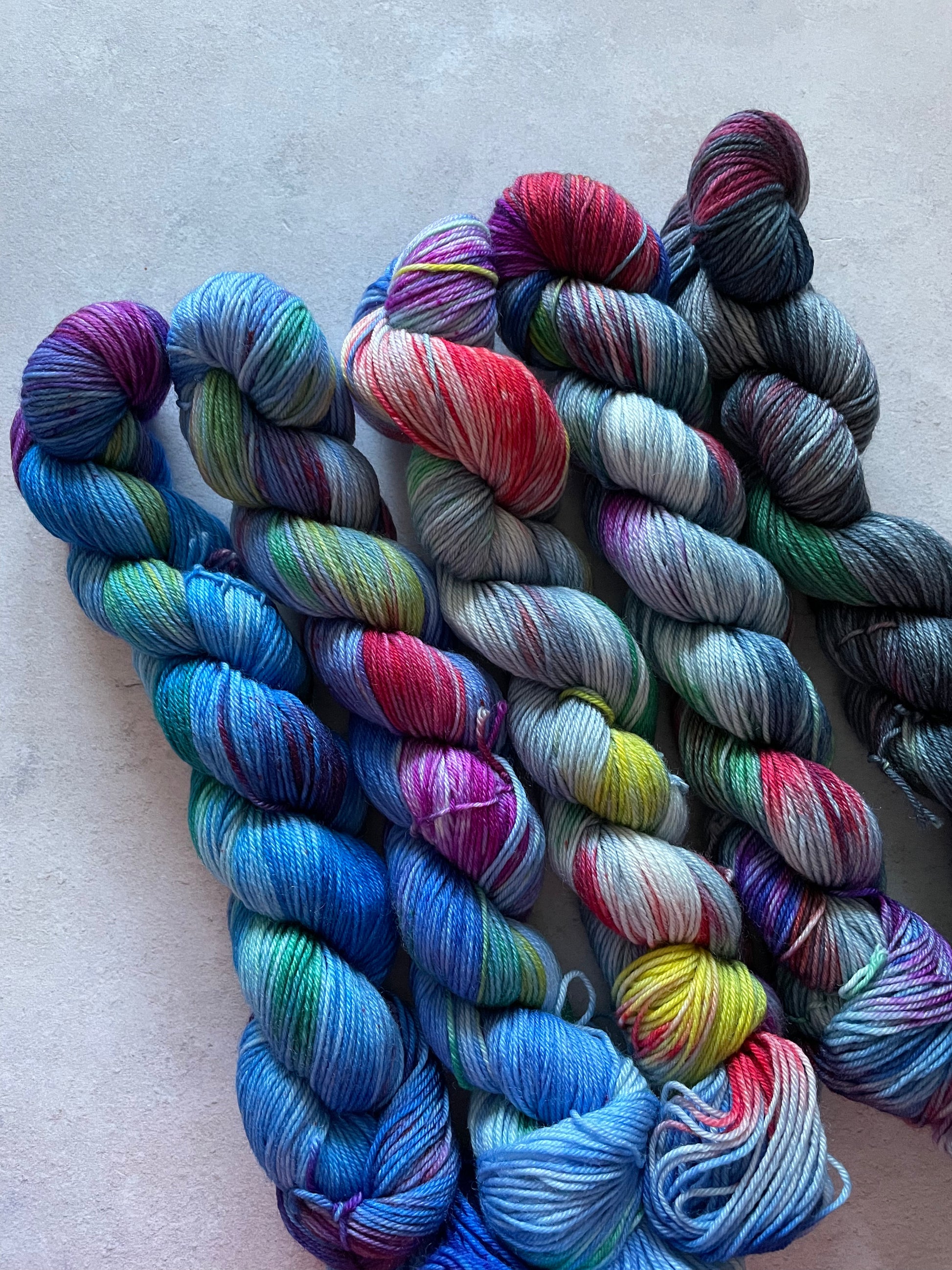 5 skeins of multicoloured and blue yarn in different shades