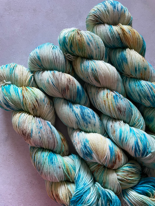 4 skeins of yarn with turquoise and brown speckles