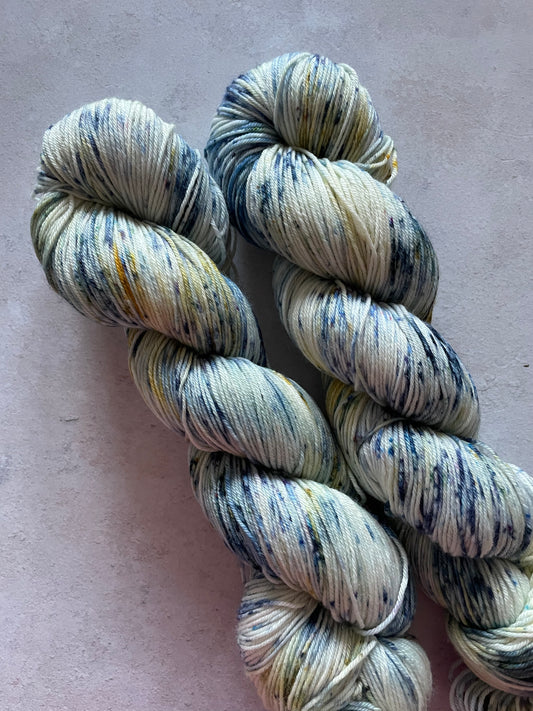 2 skeins of yarn with blue speckles and hints of gold