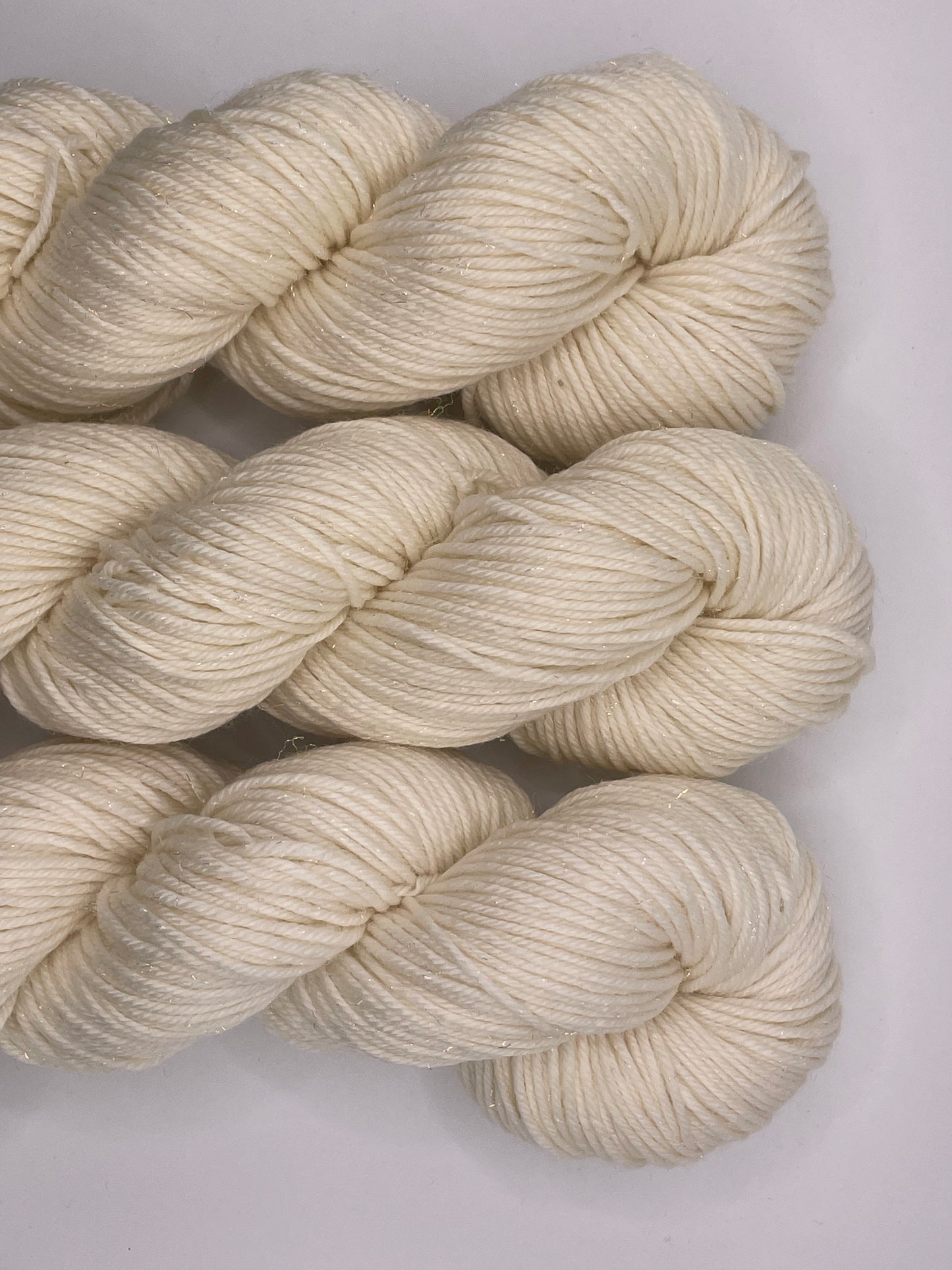 Skeins of undyed merino nylon sock yarn with iridescent stellina