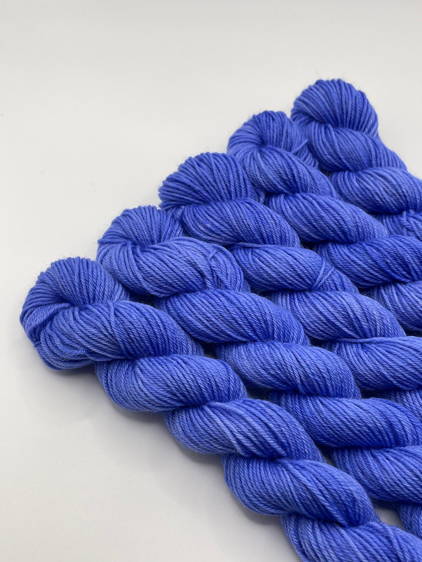 Blue yarn mini skeins on a white background