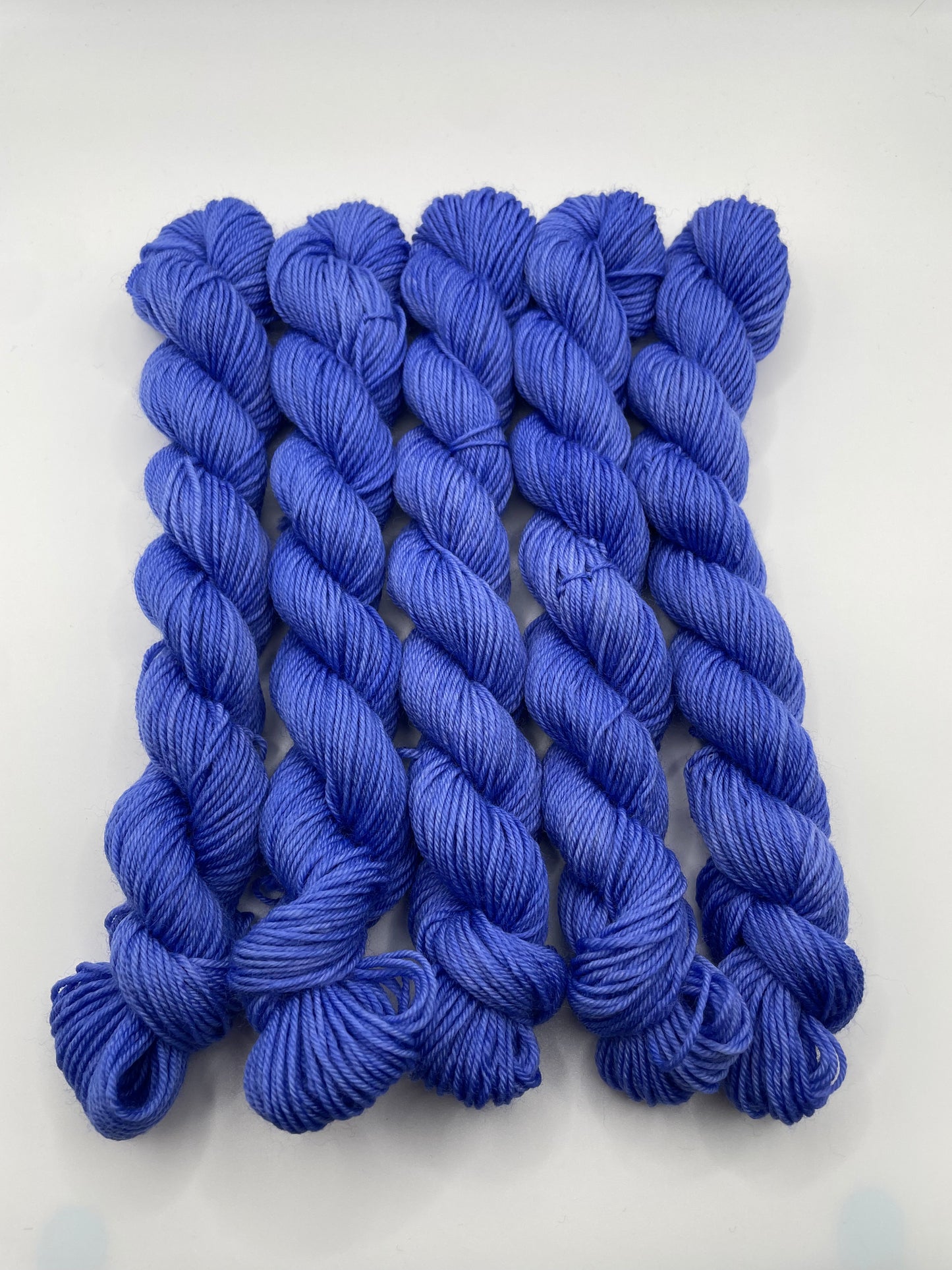 Blue yarn mini skeins on a white background