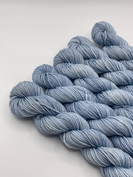 Pale blue yarn mini skeins on a white background