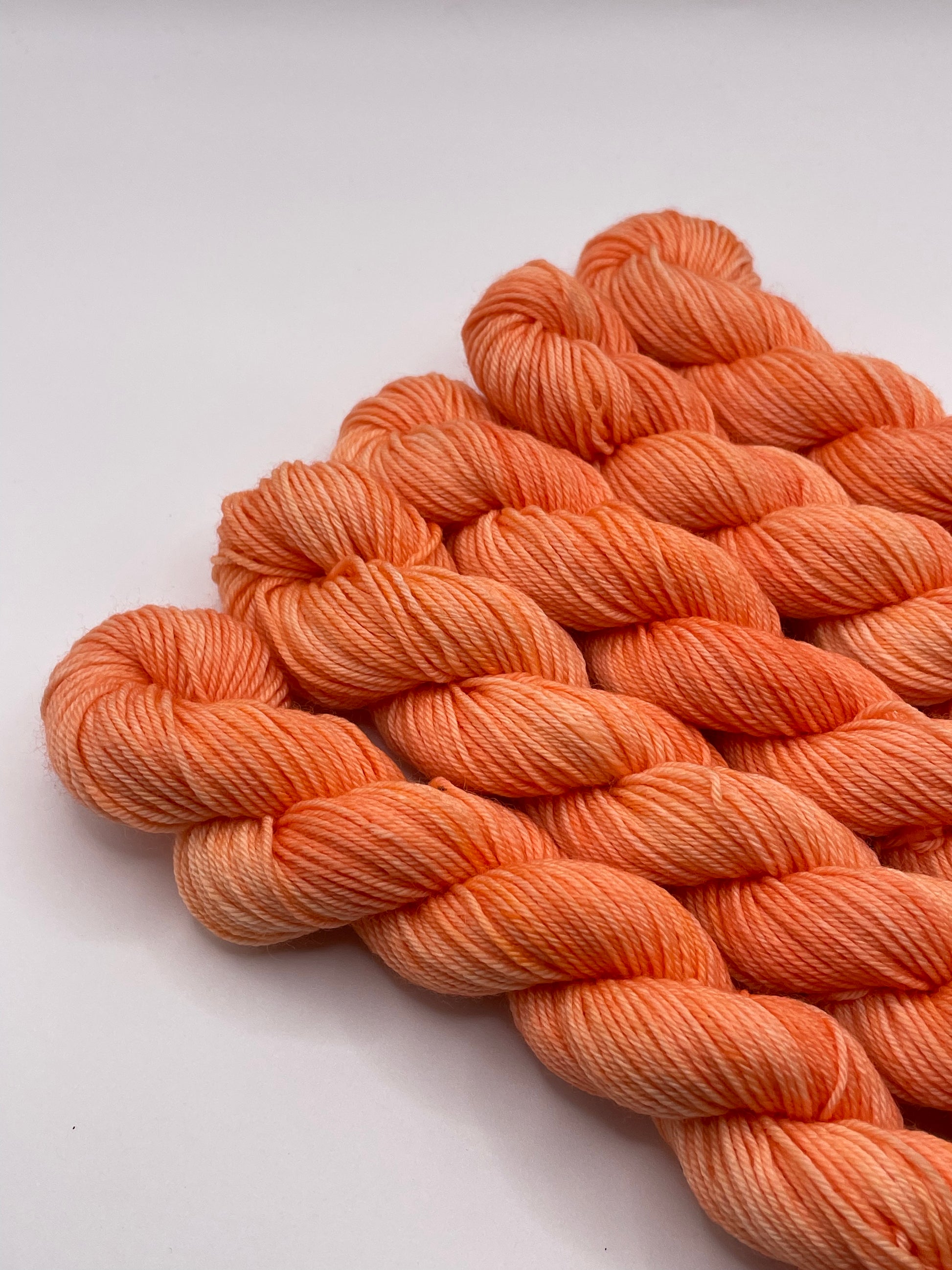 Orange yarn mini skeins on a white background