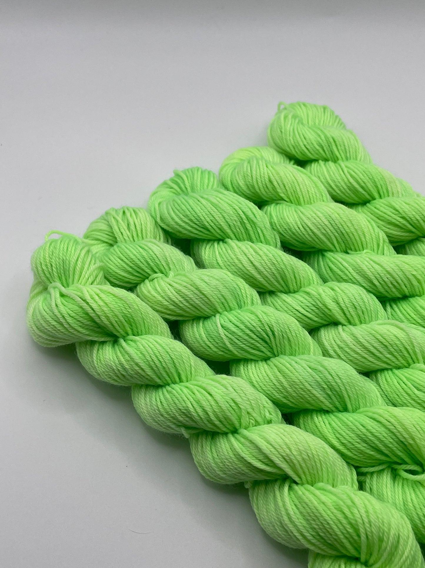 Green yarn mini skeins on a white background