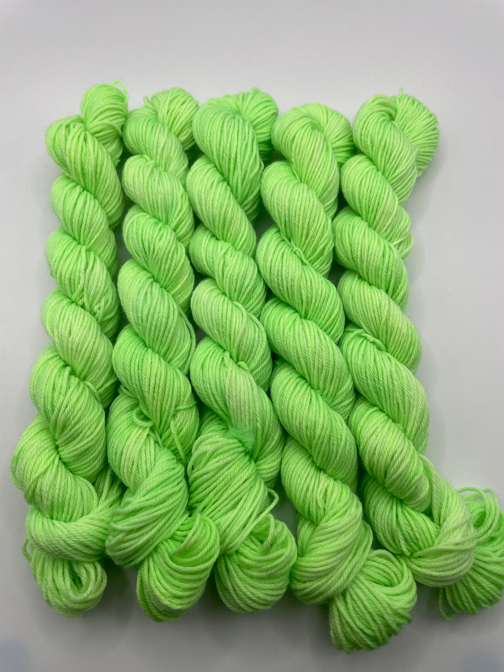 Green yarn mini skeins on a white background