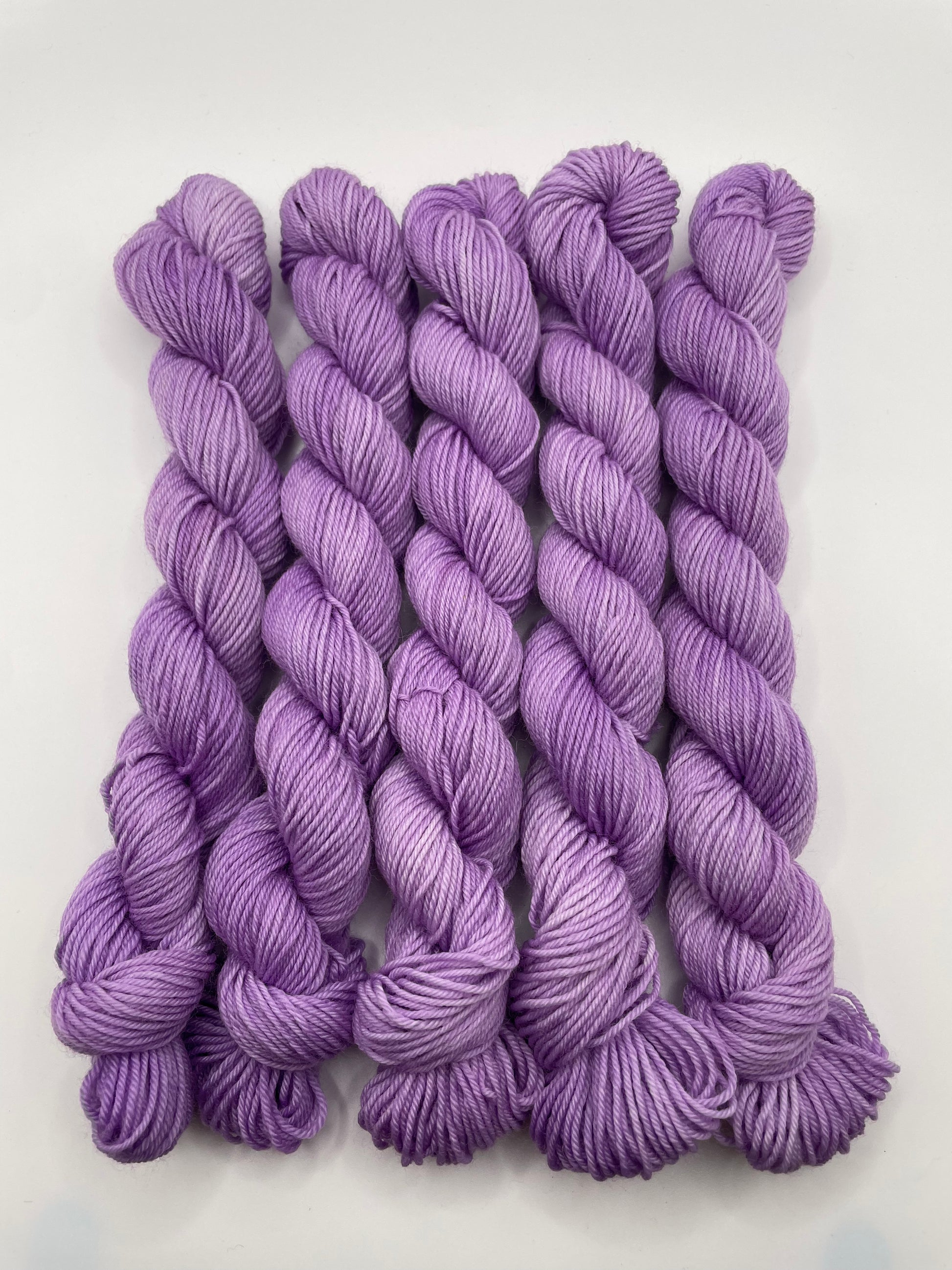 Purple yarn mini skeins on a white background