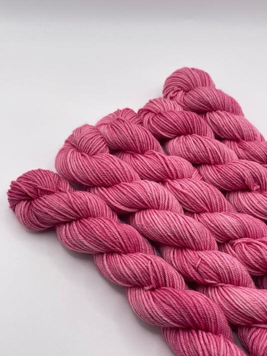 Pink yarn mini skeins on a white background