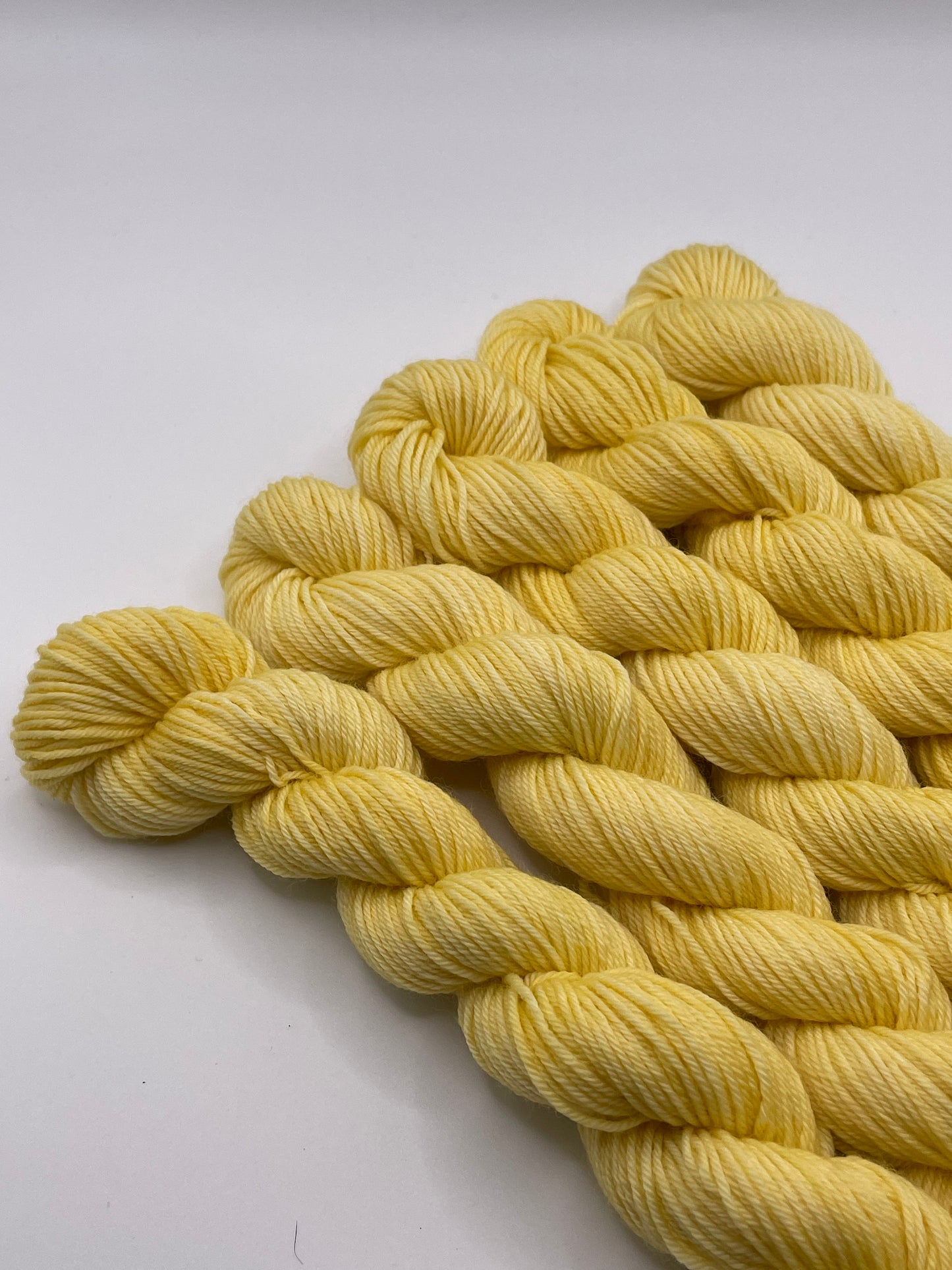 Yellow yarn mini skeins on a white background