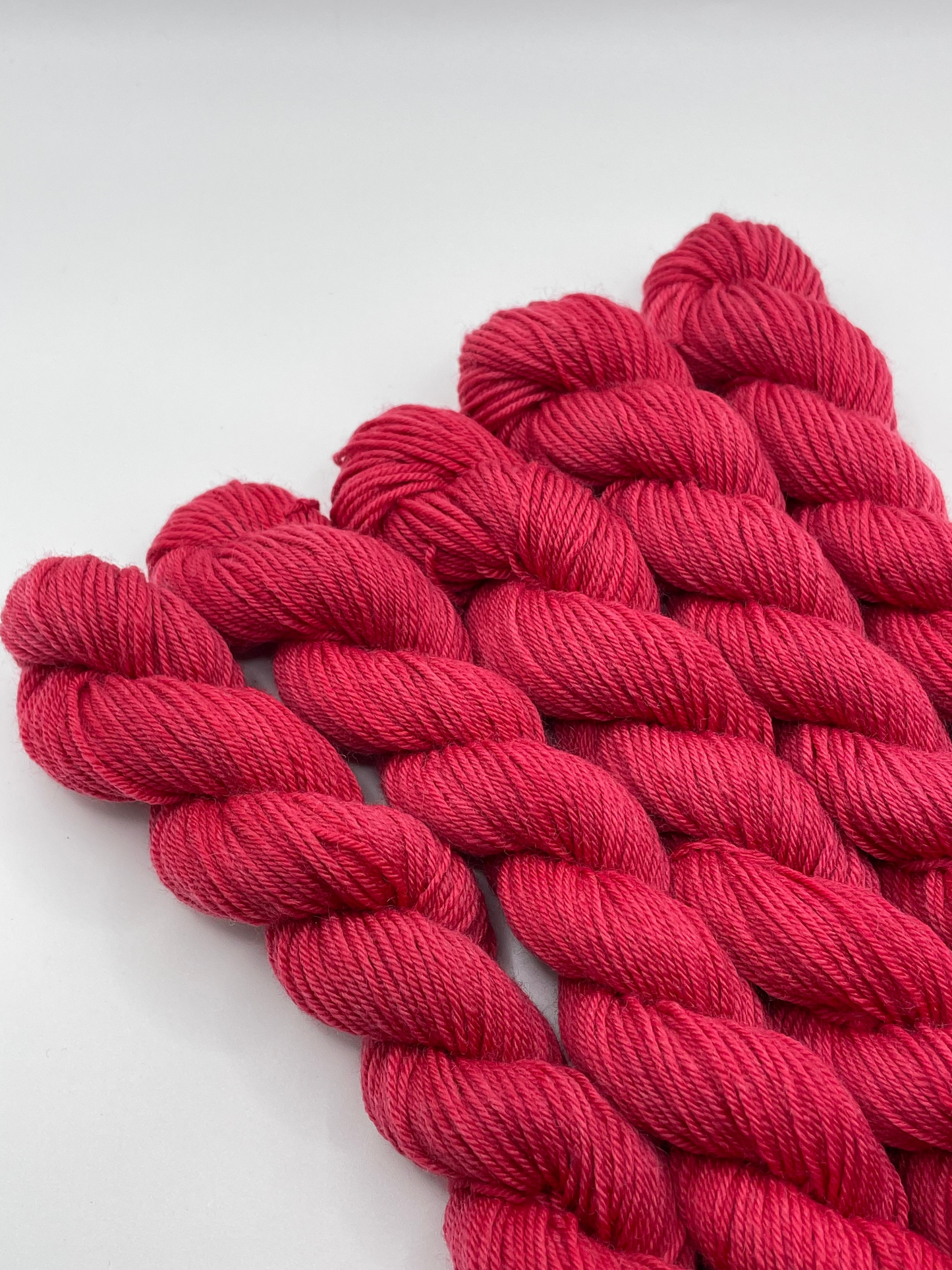Red yarn mini skeins on a white background