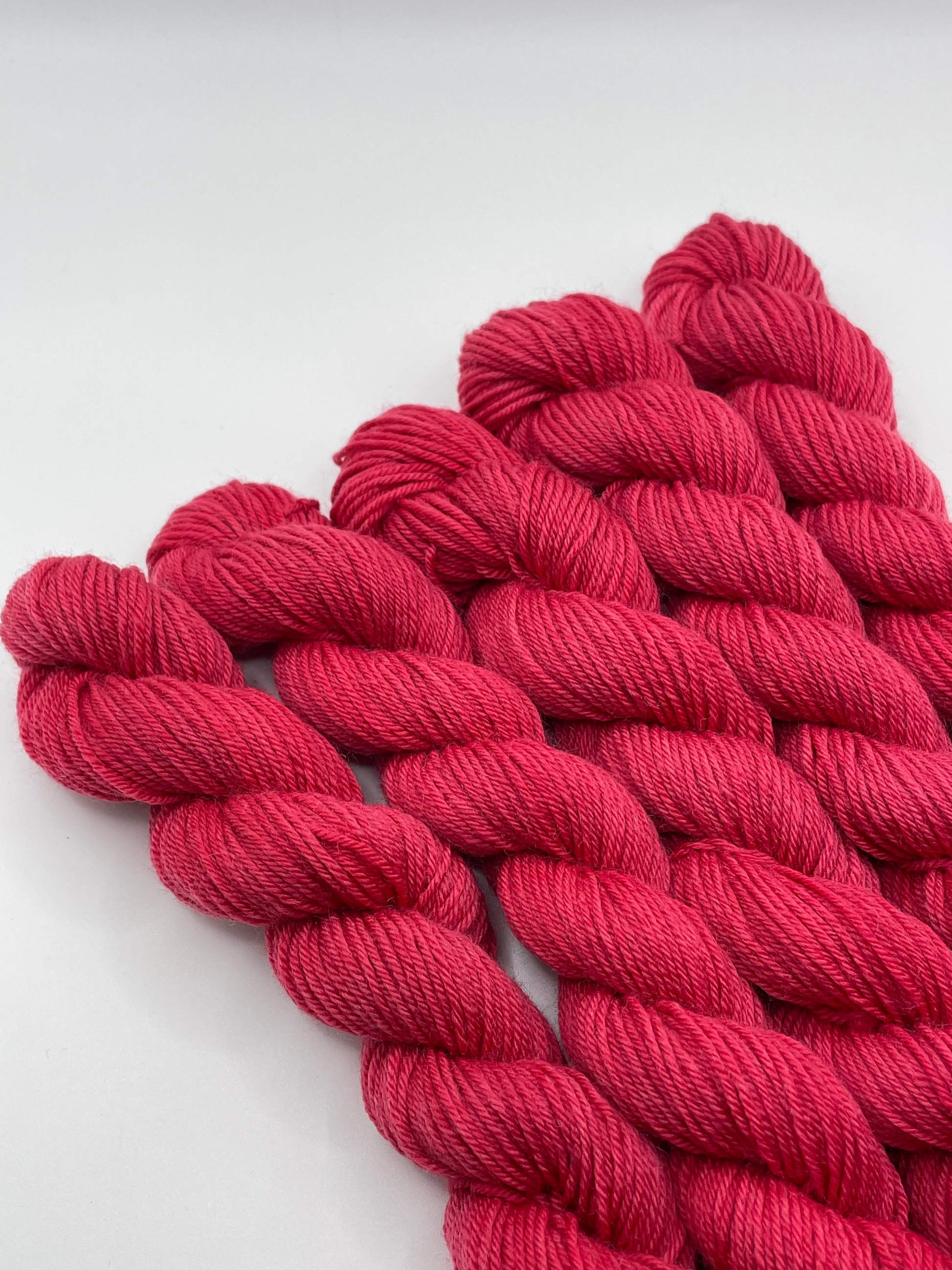 Red yarn mini skeins on a white background
