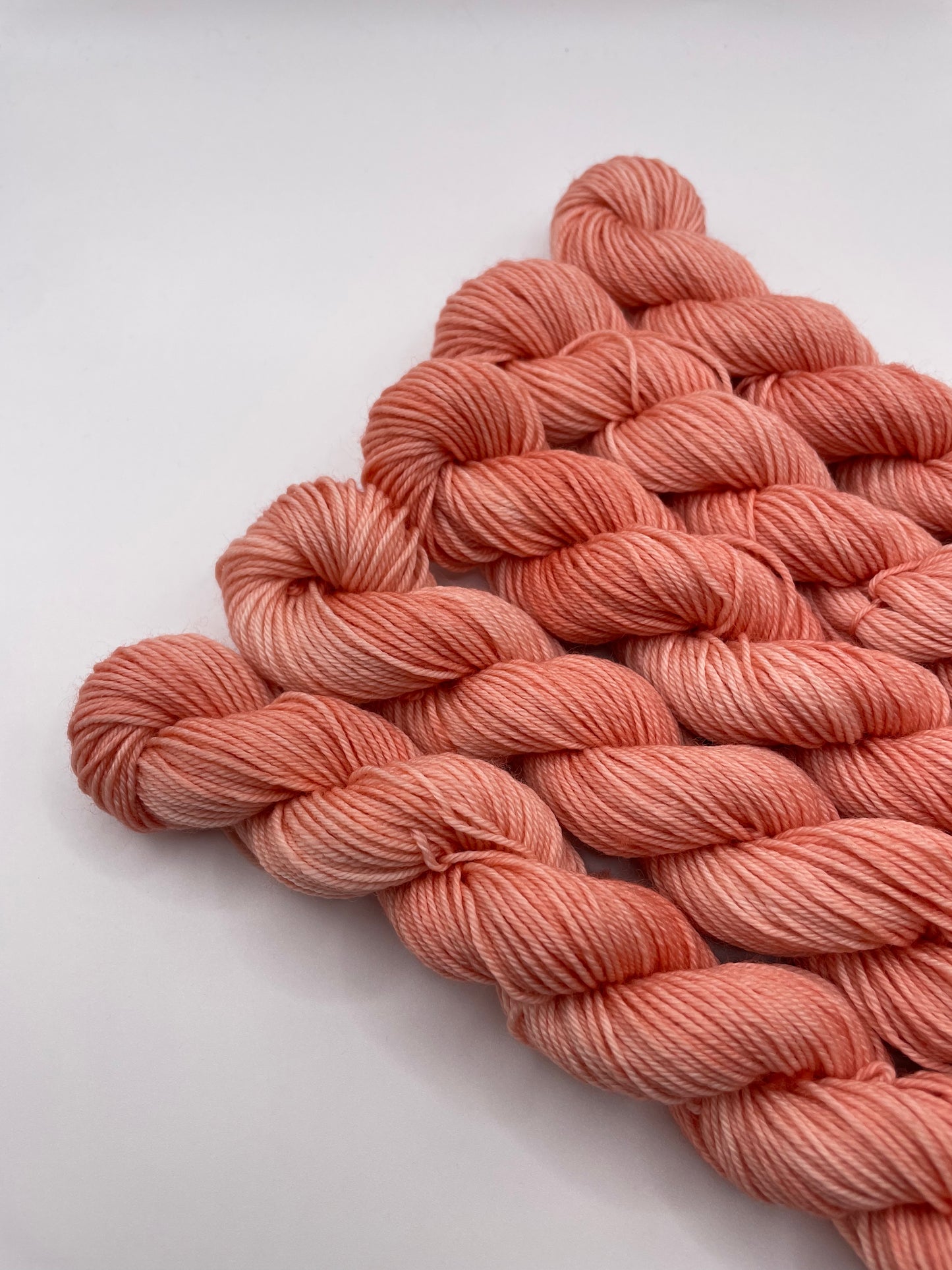 Orange red mini skeins on a white background