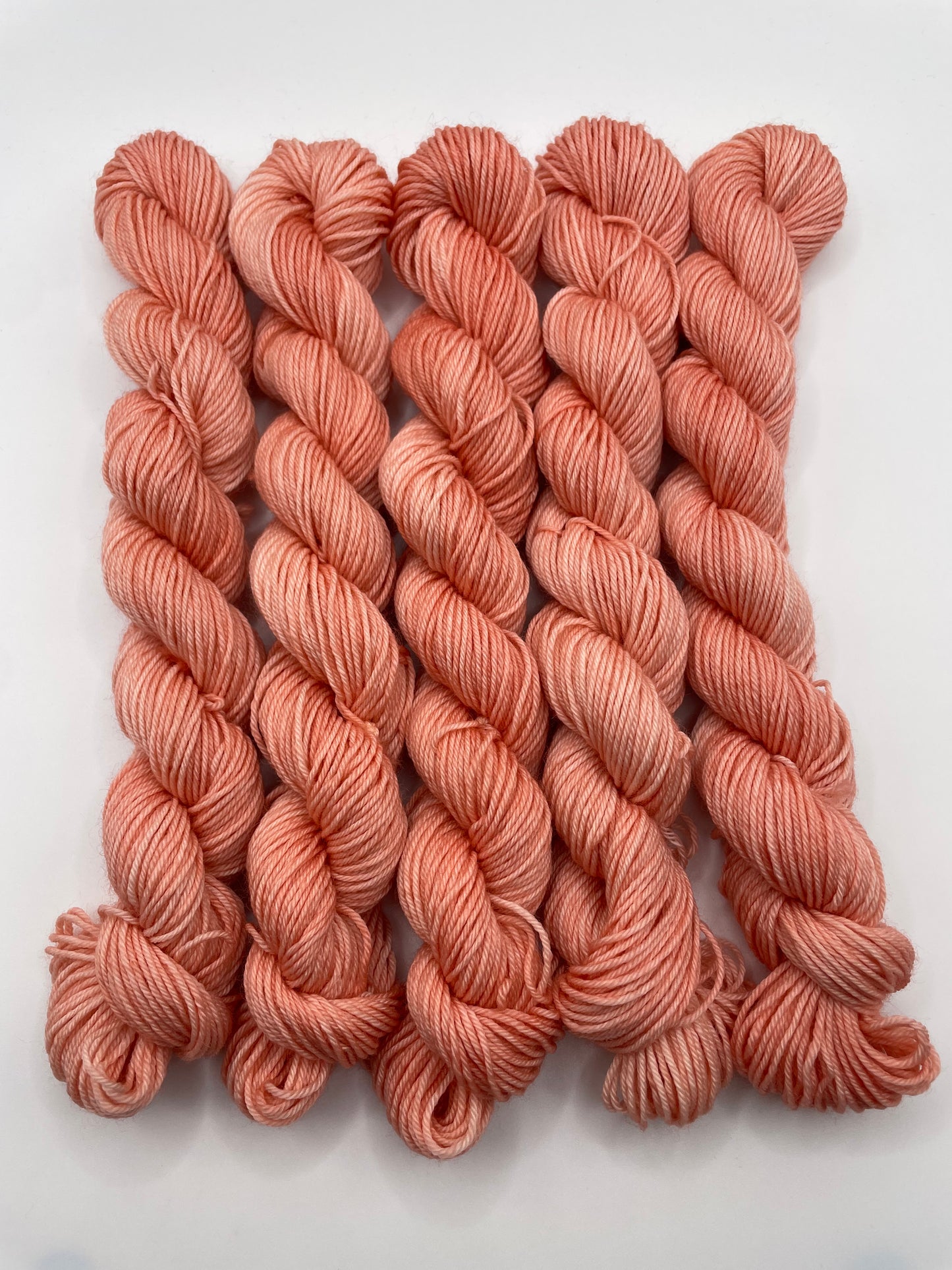 Orange red mini skeins on a white background