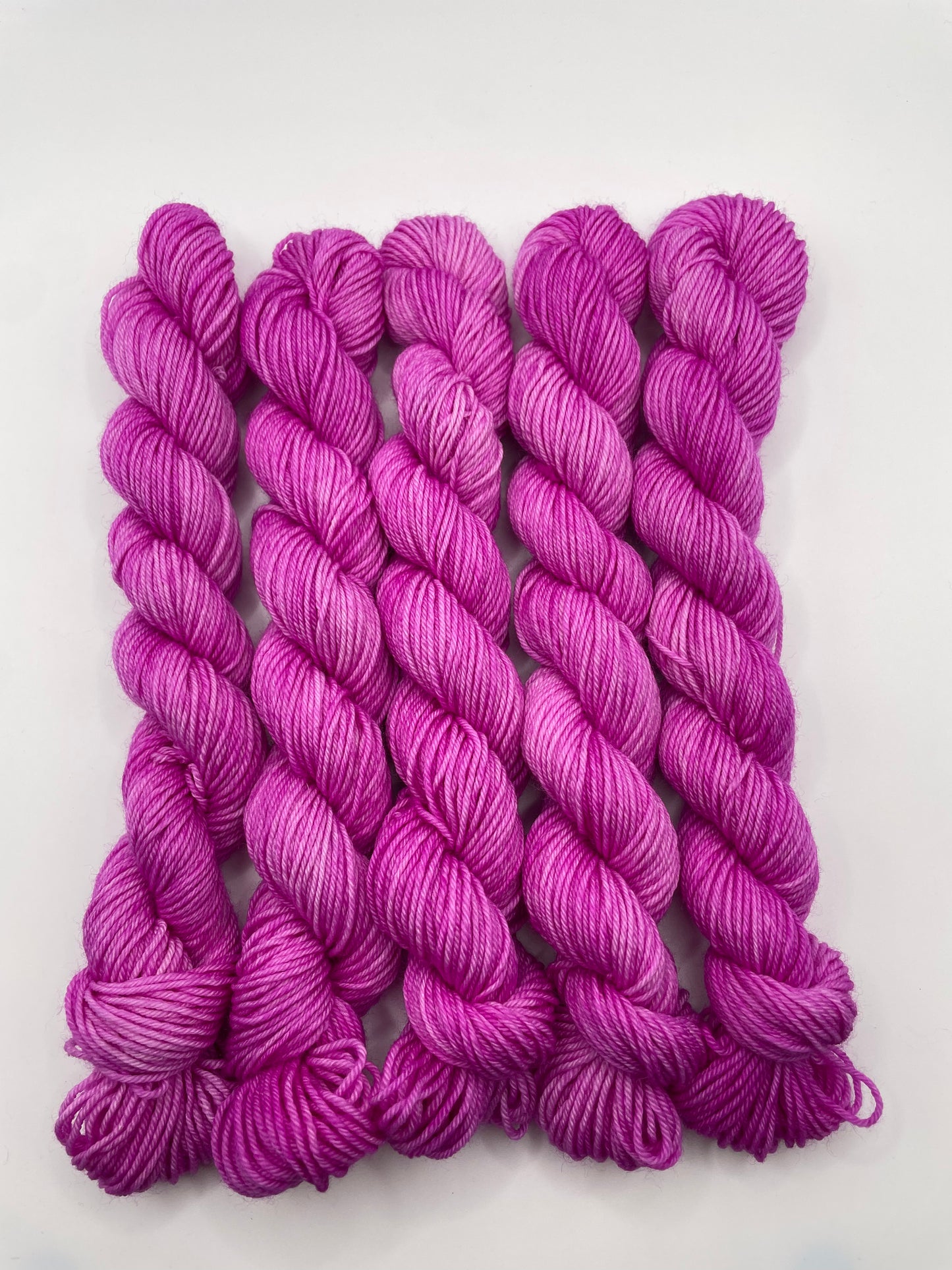 Purple yarn mini skeins on a white background