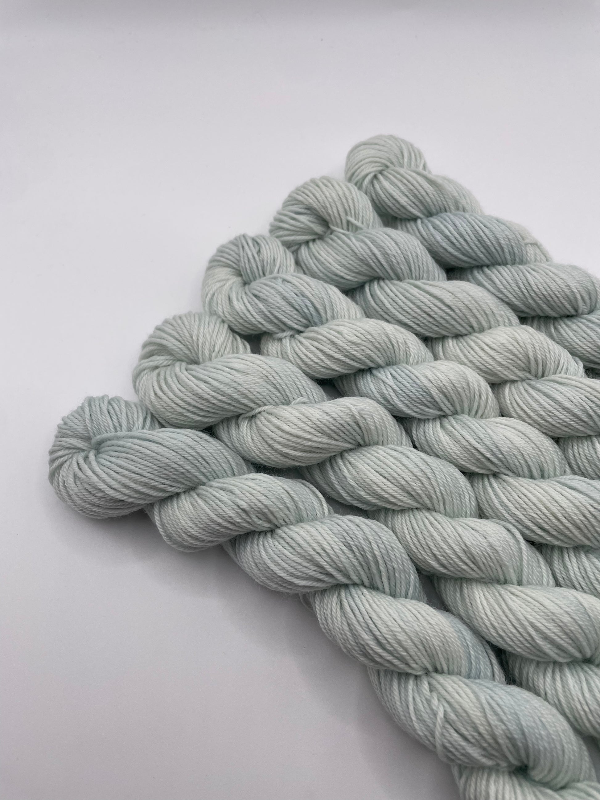 Pale mint mini skeins on a white background